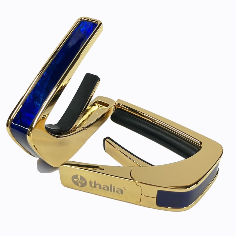 楽器種別：新品Thalia Capo/新品 商品一覧＞＞楽器アクセサリ【10，000円〜20，000円】 商品一覧＞＞カポタスト/Thalia Capo 商品一覧＞＞品揃え豊富な当店なら弦、パーツ、ケーブルなどのアクセサリーがまとめて揃います！Thalia Capo Exotic Shell Series 24K Gold Electric Blue Angel Wing タリア カポ商品説明これまでにないデザイン性と機能性に優れたカポタスト『Thalia Capos / タリア・カポ』。従来のカポとは一線を画す、見た目にも豪華なエキゾチック・ウッドやエキゾチック・シェル、彫刻や筐体のメッキ / フィニッシュ / カラーを採用したデザイン性に優れたモデルがあり、また、見た目のみならず機能面に関しても、通常のカポタストのように、使うギターの種類に合わせて1つずつカポを持ち替える必要がなく、フレットパッド(別売)をギターに合うものに交換するだけで簡単に、常にパーフェクトなテンション感とピッチ感で演奏する事を実現しました。フレットパッドのRには「0 for Classicals， 7.25， 9.5， 10， 12， 15， 16」の7種類があり、『スタンダード・テンション』と『ハイ・テンション』の計14種類。使用するギターや演奏に合わせてカスタマイズする事が可能です。・スタンダードテンション (弦に接するフレットパッド部分が標準的なモデル)・・・ 一般的なギター用・ハイテンション (弦に接するフレットパッド部分が厚いモデル)・・・ 薄いネック、12弦、ウクレレ、マンドリン、バンジョー用その他、握りこんで開く「リバース・アクション」機能が採用されており、1弦側からカポを取り付ける事で、演奏のポジションから手を返す事なくスムーズに指板上でカポを移動させる事を可能にします。Thalia Caposは様々な楽器に使用される事を想定しており、常に適切なテンション感で演奏していただけるよう全ての製品の内蔵スプリングの圧力が約7.5kgになるように、ひとつひとつ徹底した品質管理のもと製作されております。デザイン面、機能面、品質面、テンション感とピッチ感、すべてにおいてパーフェクトなカポタストです。※木目や貝模様は、天然素材を使用しているため個体により異なります。予めご了承ください。※パッケージ縮小に伴い、付属のフレッドパッドは12インチラディアス（Standard tension pad / High tension pad）2種類のみとなります。その他パッドをお求めの場合、別売にてご用意となります。イケベカテゴリ_楽器アクセサリ_カポタスト_Thalia Capo_新品 SW_Thalia Capo_新品 JAN:4525421220630 登録日:2025/02/21 カポ カポタスト
