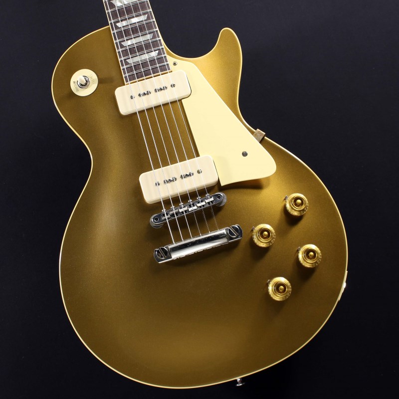 楽器種別：新品エレキギター/Gibson 商品一覧＞＞エレキギター/Gibson/Custom Shop 商品一覧＞＞エレキギター【420，000円〜790，000円】 商品一覧＞＞当店のギターは、出荷前に専門スタッフが検品・調整しているので安心です！Gibson 1956 Les Paul Standard Reissue Gold Top VOS with Faded Cherry Back (Double Gold) #6 3359商品説明国内限定仕様、59ネックシェイプにFaded Cherry Backが採用された1956 Les Paul Standardが入荷致しました！長きに亘り培われた高い製作技術と飽くなき探究心、厳選されたマテリアルにより至高のエレキギター・ベースを製作するために1993年に立ち上げられたGibson Custom Shop。現在もなお昔ながらのハンドクラフト製法と、徹底的に追求したヴィンテージの知識から製作されたカスタムショップ・ラインナップは、他所の追従を許さないほどの見事な作りとなり、プレイヤーの内に秘めるインスピレーションを際限なく沸き立たせてくれる最高の愛機となるでしょう。1952年、Les Paul Model誕生以来、58年中期までラインナップされたGold Topカラー。スタンダードシリーズにおいて、58年以降になるとチェリーサンバーストを筆頭に様々なバーストが誕生致しましたが、俄然人気を誇るカラーで御座います。Double Goldと名づけられたゴールドカラーがフィニッシュされており、見る角度、光の当たり具合によって、渋さのある深緑から、明るいグリーンゴールドの色合いまでの変化が楽しめます。昨今のGibson Cusotom ShopモデルというとMurphy Labによるエイジング加工が定番となっておりますが当モデルはVOS塗装となっておりウェザーチェックなどが入っていない艶を抑えたグロス仕上げとなっております。金属パーツはサビやくすみを再現しているためウェザーチェックやエイジング加工がお好みでない方には見逃せないオススメの一本となります。また日本国内限定仕様でLower Logo（ヘッドのGibsonロゴが通常よりも低い位置にプレイス）を採用しており、マニアの心をくすぐる一品となっております。ウッドマテリアルに関しては、メイプル2PCトップにマホガニーバック、指板にはインディアン・ローズ指板と、オーセンティックなマテリアルをセレクト。4.47kgというレスポールらしい重量を誇り、芳醇な生鳴りがアンプにプラグインする前から貴方を楽しませてくれるでしょう！通常の1956 Les Paul Standardは「50s Rounded Medium C-Shape」を採用しておりますが当モデルは59年仕様の「Authentic ’59 Medium C-Shape」を採用しており太すぎず細すぎず、現代的なプレイスタイルにも対応できる仕上がりとなっております。手のサイズ的に太目のネックシェイプを苦手とする方も多い傾向にある日本のユーザーの方々にも安心してお使い頂けます！サウンドの肝となるピックアップに関しては、P-90ピックアップ搭載により、ブルースやクラシックロックだけではなく、現代的なポップミュージックにもマッチしたサウンドをアウトプットしてくれます。本機の豊かなボディ鳴りがミックスされることで、アンプを選ぶこと無くクリーンサウンドではウェットで太く美しく。そしてゲインを上げたドライブサウンドでは自然な中域の膨らみとシングルコイル特有のバイト感の絶妙な融合により、至福の時間をお楽しみ頂けます。　コントロールは2Vol、2Tone仕様にペーパーオイルコンデンサーを装備。ボリューム・カーブの効きは素早く8メモリ辺りからゲインが退き、手元の操作でクリーンサウンドからドライブサウンドまでを自在に操ることができます。トーン・コントロールに関しては、5メモリまではアタック感が残り、お好みのソリッド感を作ることが可能となります。Gibsonの提唱するシングルコイルとはなにか！王道でも有り、一つのマスターピースとも言えるこの56LPを手に取ればご体感頂ける事でしょう！！この機会お見逃し無く！！#6　3359約4.47kgハードケース付属商品詳細【SPEC】Body: 1pc Mahogany Back，2pc Plain Maple Top， Hide Glue FitNeck: 1-Piece Mahogany with Long Neck TenonFingerboard: Dark RosewoodProfile: Authentic ’59 Medium C-ShapeFrets: Historic Medium-JumboNut: NylonBridge：No-Wire ABR-1Tailpiece：Lightweight Aluminum Stop BarMachinehead: Kluson ReissuePickups: Custom Soapbar P-90Controls: 2 volume 、2 tone 、3-way switchイケベカテゴリ_ギター_エレキギター_Gibson_Custom Shop_新品 JAN:4570155999086 登録日:2024/01/02 エレキギター ギブソン カスタムショップ