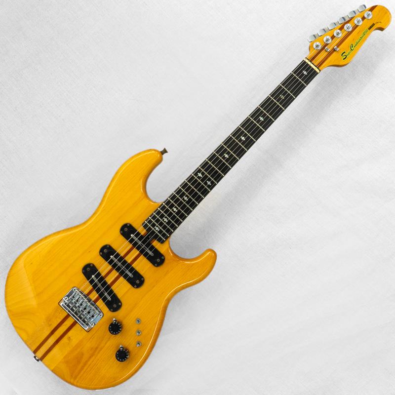 楽器種別：ヴィンテージYAMAHA/Other Models 商品一覧＞＞YAMAHA/ユーズド 商品一覧＞＞エレキギター【65，000円〜135，000円】 商品一覧＞＞その他/YAMAHA 商品一覧＞＞当店のギターは、出荷前に専門スタッフが検品・調整しているので安心です！YAMAHA VINTAGE SC-1200 '78 Yellow Natural商品説明1960年代の国産ギター黎明期より、独自色の強いオリジナルモデルを多数開発してきたヤマハ。特に1970年代からはSGやBBなどのヒットモデルを輩出し、ジャパンヴィンテージファンを中心に国内外問わず高い評価を得ています。今回入荷はシリアルナンバーから1978年頃の製造とみられる「SC-1200」、1977年頃にスタートした当時のニューモデル最上位機種となります。【ボディ】全体重量約3.75kg。STタイプを意識したようなシェイプのボディ材（ウィング材）はアルダーを採用、イエローナチュラルカラーにてフィニッシュした一本。全体的な傷や打痕、金属パーツのくすみなどのダメージは散見されますが、塗装はしっかりと艶が残っており年式を考慮すれば十分にキレイなコンディションと言えるでしょう。【ネック】ネックマテリアルはメイプル/マホガニーの5ピース、ローズウッド指板。スルーネック仕様となります。ネック裏は小さい傷は散見されますが、大きな打痕などはございません。チューナーは巻き具合に若干のバラつきがあるもののしっかりと機能しております。フレット、ナットは若干減りが見られ、ハイ起き傾向がございますが現状の弦高で極端なビビりや詰まりはございません。ローアクションに設定する場合はすり合わせ調整をお勧めいたします。ナット幅約41.8mm。ヤマハらしいスマートなネックシェイプが特徴です。【電装系】コントロールは【1ヴォリューム／1トーン】と非常にシンプルですが、3つの「スリーポジション・フェイズスイッチ」が肝となります。各ピックアップの位相とOFFを切り替え可能で、全13パターンの組み合わせを実現。バイサウンドこそ搭載されていませんが、非常に多彩なサウンドバリエーションが楽しめます。付属品：ソフトケース商品詳細Weight：3.75kgBody Material：AlderNeck Material：Maple/Mahogany， 5 pieceFingerboard：RosewoodNut Width：41.8mmFret Width：2.0mmNeck Thickness（1F／7F／12F）：21.3mm／22.3mm／22.8mmPickups（Neck／Bridge）：YAMAHA C-I（4.7kΩ／4.8kΩ／4.6kΩ）※ピックアップの直流抵抗値はコントロール部を通した計測となります-------Heartman Vintage Guitarsは池部楽器店のヴィンテージ・ギター＆ベースの専門店です-------イケベカテゴリ_エレキギター_その他_YAMAHA_Other Models_ユーズド SW_YAMAHA_ユーズド JAN:2500010872300 登録日:2026/08/07 エレキギター ヤマハ やまは