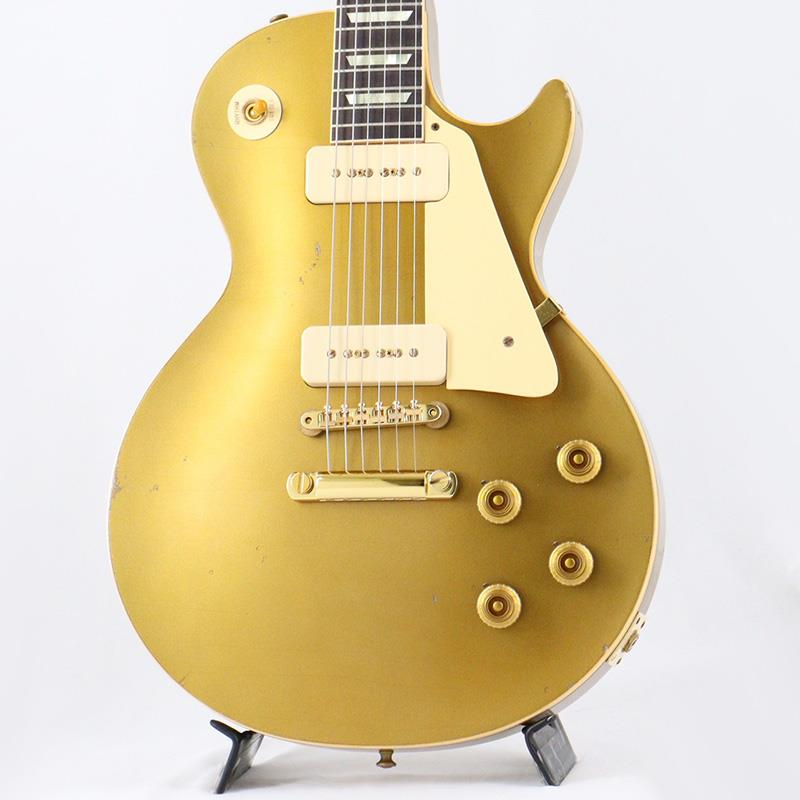 楽器種別：新品Gibson/Custom Shop 商品一覧＞＞Gibson/新品 商品一覧＞＞エレキギター【645，000円〜1，205，000円】 商品一覧＞＞レスポールタイプ/Gibson 商品一覧＞＞当店のギターは、出荷前に専門スタッフが検品・調整しているので安心です！Gibson 1956 Les Paul Standard Reissue with Gold Hardware Murphy Lab Light Aged (All Double Gold) 【Weight≒3.99kg】商品説明Global Limited Editionゴールドハードウェアの1956 Les Paul Standard Reissueが入荷いたしました！！長きに亘り培われた高い製作技術と飽くなき探究心、厳選されたマテリアルにより至高のエレキギター・ベースを製作するために1993年に立ち上げられたGibson Custom Shop。現在もなお昔ながらのハンドクラフト製法と、徹底的に追求したヴィンテージの知識から製作されたカスタムショップ・ラインナップは、他所の追従を許さないほどの見事な作りとなり、プレイヤーの内に秘めるインスピレーションを際限なく沸き立たせてくれる最高の愛機となるでしょう。〜Murphy Labとは〜カスタムショップ内に誕生したMurphy Lab（マーフィー・ラボ）は、ナッシュヴィルのギブソン・カスタムショップ内に新設されたラボで、科学的検証に基づく最新の技術を駆使して、ギターのエイジング（ヴィンテージ・ギターの経時変化した外観と弾き心地を再現する処理）を専門に行います。ギブソン・カスタムショップの立ち上げ時のメンバーであり、ヒストリック・コレクション開発のプロジェクト・リーダーとして尽力したトム・マーフィーは、その後新品のギターにヴィンテージのルックスとフィーリングをもたらすエイジングというテクニックで活躍してきました。トムのヴィンテージ・ギターへの情熱と深い知識に裏打ちされた技術によって、ギブソン・ギターの自然なラッカーのクラック、演奏による摩耗を見事に再現しています。トム・マーフィーとギブソンは、経時変化によりウェザーチェックと呼ばれるクラックを生じさせる、1950年代、1960年代のニトロセルロースラッカーを科学的に解析し、その変化のプロセスをひも解き、あらゆるモデルのプロトタイプによるテストを重ねて、ヴィンテージ同様のナチュラル・ウェザーチェックを再現するラッカー・プロセスを開発しました。マーフィー・ラボは、トム・マーフィーがギブソン・カスタムショップのチームを率いて、プロトタイプをもとに、あらゆるボディシェイプ、フィニッシュ、エイジング・レベルの検証を始めたことから、その構想が生まれました。その結果、これまでにないリアリティとこだわりを追求したエイジングを行うために、ギブソン・カスタムショップ内に設立されました。トム・マーフィーの存在と、その芸術的な作品の数々は、ギブソンの歴史の中で重要な役割を果たし、今もそしてこれからもマーフィー・ラボとして永遠に引き継がれていきます。本機は4段階で設けられたエイジング・レベルの中で2番目となる「Light Aged」が施された1956 Les Paul Standard Reissue。より高密度なウェザーチェックとライトエイジド・ハードウェアにより、ホームで弾かれてきたギターの経時変化、演奏による摩耗を再現。1952年、Les Paul Model誕生以来、58年中期までラインナップされたGold Topカラー。スタンダードシリーズにおいて、58年以降になるとチェリーサンバーストを筆頭に様々なバーストが誕生致しましたが、俄然人気を誇るカラーで御座います。Double Goldと名づけられたゴールドカラーがフィニッシュされており、見る角度、光の当たり具合によって、渋さのある深緑から、明るいグリーンゴールドの色合いまでの変化が楽しめます。また当個体はゴールドハードウェアを採用した特別仕様。All Double Goldフィニッシュにゴールドハードウェアとゴールドづくしですがいやらしさがなく上品さを感じられるのはMurphy Labによるエイジングが成す業といえるでしょう。ウッドマテリアルに関しては、メイプル2PCトップにマホガニーバック、指板にはインディアン・ローズ指板と、オーセンティックなマテリアルをセレクト。3.99kgいうLes Paulらしいウェイトから出る芳醇な生鳴りがアンプにプラグインする前から貴方を楽しませてくれるでしょう！ネックシェイプは「1950s Chunky D」シェイプを採用。59LPに比べ肉付きのあるシェイプではありますが、所謂丸太の様なシェイプでは御座いません為、手のサイズ的に太目のネックシェイプを苦手とする方も多い傾向にある日本のユーザーの方々にも安心してお使い頂けます！ヘッドのGibsonロゴが通常よりも低い位置にプレイスされたLower Logoを採用しており、マニアの心をくすぐる一品となっております。サウンドの肝となるピックアップに関しては、P-90ピックアップ搭載により、ブルースやクラシックロックだけではなく、現代的なポップミュージックにもマッチしたサウンドをアウトプットしてくれます。本機の豊かなボディ鳴りがミックスされることで、アンプを選ぶこと無くクリーンサウンドではウェットで太く美しく。そしてゲインを上げたドライブサウンドでは自然な中域の膨らみとシングルコイル特有のバイト感の絶妙な融合により、至福の時間をお楽しみ頂けます。　コントロールは2Vol、2Tone仕様にペーパーオイルコンデンサーを装備。ボリューム・カーブの効きは素早く8メモリ辺りからゲインが退き、手元の操作でクリーンサウンドからドライブサウンドまでを自在に操ることができます。トーン・コントロールに関しては、5メモリまではアタック感が残り、お好みのソリッド感を作ることが可能となります。Gibsonの提唱するシングルコイルとはなにか！王道でも有り、一つのマスターピースとも言えるこの56LPを手に取ればご体感頂ける事でしょう！！この機会お見逃し無く！！商品詳細■Weight≒3.99kg■S/N: 6 6181BodyBody Shape: Les PaulBody Material: MahoganyTop: MapleWeight Relief: NoneBody Finish: Light Aged nitrocellulose lacquerNeckNeck Material: MahoganyProfile: 1950s Chunky DScale Length: 628.65mm / 24.75inFingerboard Material: RosewoodFingerboard Radius: 12 in. | 304.8 mmFret Count: 22Frets: Narrow TallNut Material: NylonInlays: TrapezoidJoint: Long neck tenonHardwareFinish: GoldBridge: ABR-1 Tune-O-MaticTailpiece: Stop BarTuning Machines: Kluson DeluxeControl Knobs: Gold Top HatsPickup Covers: Cream SoapbarPlastic Parts: CreamElectronicsNeck Pickup: Custom Soapbar P-90Bridge Pickup: Custom Soapbar P-90Controls: 2 Volume， 2 TonePickup Selector: 3-way toggleOutput Jack: 1/4カスタムショップ・ブラウン・ハードケース、認定書、他付属イケベカテゴリ_エレキギター_レスポールタイプ_Gibson_Custom Shop_新品 SW_Gibson_新品 JAN:4570156026316 登録日:2026/08/07 エレキギター ギブソン カスタムショップ