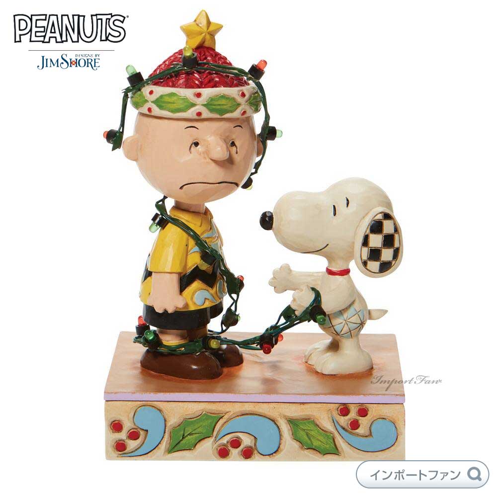 ジムショア スヌーピー＆チャーリーブラウン デコレーション クリスマス ピーナッツ 6008954 Snoopy Charlie Brown Tangled Lights JimShore は、表情や仕草がとってもキュートなスヌーピーとチャーリーブラウンをモチーフにした作品です。 スヌーピーがチャーリー・ブラウンをクリスマスツリーに見立てて、デコレーションする様子が描かれております。 チャーリー・ブラウンがしかめっ面で少し嫌そうな表情をしているところが面白い作品となっております。 単4電池×2本（別売り）使用で実際にライトアップします。 コレクションはもちろん、誕生日のプレゼント、お友達や大切な方への贈り物やお祝いのギフトとしてもオススメのジムショア Jim Shore 作品です。■サイズ：W10.1×H14.9×D6.6cm■重量：-　g■素材：ストーンレジン製 ■Jim Shore（ジムショア）米国南部出身のアーティスト、Jim Shore(ジム・ショア)氏により作り上げられた人気のディズニー作品。ストーンレジンで成型し、熟練された職人の手によって一つ一つハンドペイントにより仕上げられるため同じ作品でも世界でただ一つだけの作品となっています。まるで木工品のような温もりのあるノスタルジックな雰囲気のフィギュア作品は、贈り物やコレクションとしてもオススメの逸品です。■お届けについて 日本では発売されていないレアなアイテムをできるだけたくさん皆様の元へお届けするため、ご注文からお届けまでに3週間前後かかります。 通関等により、予定よりもお時間がかかる場合がございます。当店に到着次第すぐに発送させていただきます。 ■ご注意・お客様ごとのオーダー受注のため、受注確認後の変更、キャンセルはできませんのであらかじめご了承の上、ご購入くださいませ。・Jim Shoreは、すべて手作業で作られているため、同じシリーズであってもひとつひとつ違った表情をしております。また、ブラウザやモニターの環境等により実物の色合いが画像と若干異なる場合がございます。予め、ご了承くださいませ。なお、「イメージ違い」等お客様都合での返品は承れません。・ジムショアは、ヴィンテージ風に仕上げた作品のため、あえて塗り残しや欠けを作ったり、まっすぐではない膨らみのあるラインや、ムラのある彩色や彫刻刀で削ったような跡などがみられます。 これらは商品不良ではなく、どの作品にもみられるデザインのため、これを理由にした返品や交換はお受けいたしかねます。 ヴィンテージ風の手仕事感を感じられる作風がジムショアの魅力となっております。その魅力あふれる作品を存分にお楽しみください。・日本の税関で開封検査を受けますので、箱には必ず開封した跡やテープ痕があります。また、発表されてから年数の経った作品や絶盤作品等は箱などが経年変化によりヤケや汚れがあることもございます。中は全て新品・未使用のものですので、ご安心くださいませ。・他店舗でも販売しておりますため、在庫の個数がございましても、完売もしくはお取り寄せとなる場合がございます。