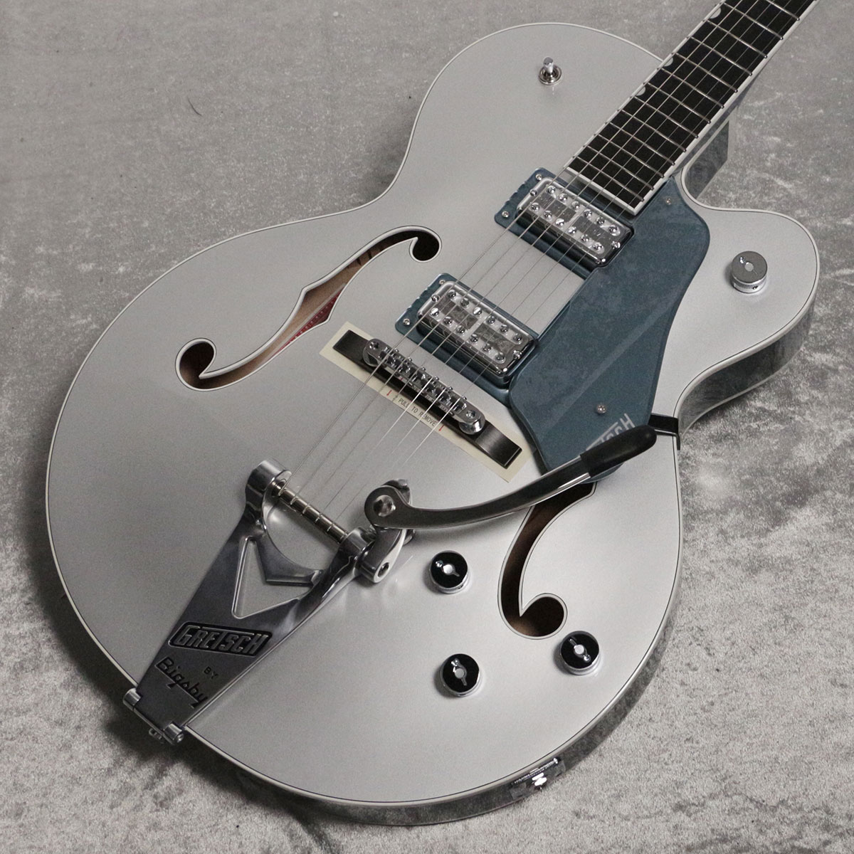 140周年の特別な"グレッチ"140th Anniversaryシリーズ登場！ 2023年、Gretschブランドは創業年から”ダブルプラチナ”となる140周年という大きな節目を迎えます。 140年にわたる確かなサウンドを祝して開発されたLimited Edition G6118T-140 は、インスピレーションに満ちたグレッチの歴史を称え、次世代のサウンドスケープを作り出すプレイヤーに優れたパワーとトーンを提供します。 主な特徴： ・ソリッドアディロンダックレッドスプルーストップ、メイプルバック＆サイド ・MLブレイシング ・22本のミディアムジャンボフレットと、パーロイドNeo-Classic サムネイルインレイを備えた、12インチラジアスエボニー指板 ・FT-67 Filter?Tronハムバッカー ・エボニーベースのAdjusto-Maticブリッジ ・ストリングスルー式のBigsby B6CPテイルピース ・Gotohロッキングチューナー ・140周年記念ヘッドプレート ・クロムハードウェア ・ニトロセルロースラッカーフィニッシュ ・Gretsch 16インチデラックスホロウボディハードシェルケース付属 製品ハイライト： 【MLブレイシングのアディロンダックレッドスプルーストップ】 16インチ幅のホロウボディにソリッドアディロンダックレッドスプル ースをトッピング、バック＆サイドにはラミネートメイプルを採用しています。 内部はMLブレイシングで補強されています。 【フラッグシップFT-67 Filter?Tronピックアップ】 FT-67 Filter?Tronハムバッカーは、ヴィンテージGretschヴォイシングを再現しつつ、現代の演奏スタイルに合わせたトーンが得られるように設計されています。 このパワフルなピックアップは、オープンで煌めくトップエンド、艶のあるミッドレンジ、力強いローエンド、バランスの取れたハーモニクスを提供し、バンドアンサンブルで他の楽器とシームレスにブレンドする音色を実現します。 【多彩なコントロール】 各ピックアップのボリュームコントロール、マスターNo-Loadトーン、トレブルブリード回路付きマスターボリュームとを備え、直感的なサウンド設計が可能です。 【140周年記念仕様】 G6118T-140は、Stone Platinumのボディバック＆サイドにPure Platinumのボディトップを重ねたフィニッシュで、ピックガードとピックアップベゼル、GArrowコントロールノブ、シルバーバインディング、140周年記念ヘッドプレートが付いたマッチングヘッドストックといった特別な仕様でまとめ上げられています。 製品仕様 Body Material Laminated MapleBody Finish Gloss Nitrocellulose LacquerNeck Maple, Standard “U”Neck Finish Gloss Nitrocellulose LacquerFingerboard Ebony, 12” &#40;305 mm&#41;Frets 22, Medium JumboPosition Inlays Pearloid Neo-Classic Thumbnail &#40;Ebony&#41;Nut &#40;Material/Width&#41; Bone, 1.6875” &#40;42.86 mm&#41;Tuning Machines Gotoh LockingScale Length 24.6” &#40;625 mm&#41;Bridge Adjusto-Matic with Ebony BasePickguard Stone Platinum Plexi w/ Silver Gretsch Logo &#40;974&#41;Pickups FT-67 Filter’Tron &#40;Bridge&#41;, FT-67 Filter’Tron &#40;Neck&#41;Pickup Switching 3-Position ToggleControls Volume 1. &#40;Neck Pickup&#41;, Volume 2. &#40;Bridge Pickup&#41;, Master Volume, Master ToneControl Knobs Jeweled ArrowHardware Finish ChromeStrings Nickel Plated Steel &#40;.011-.049 Gauges&#41;Case/Gig Bag Included