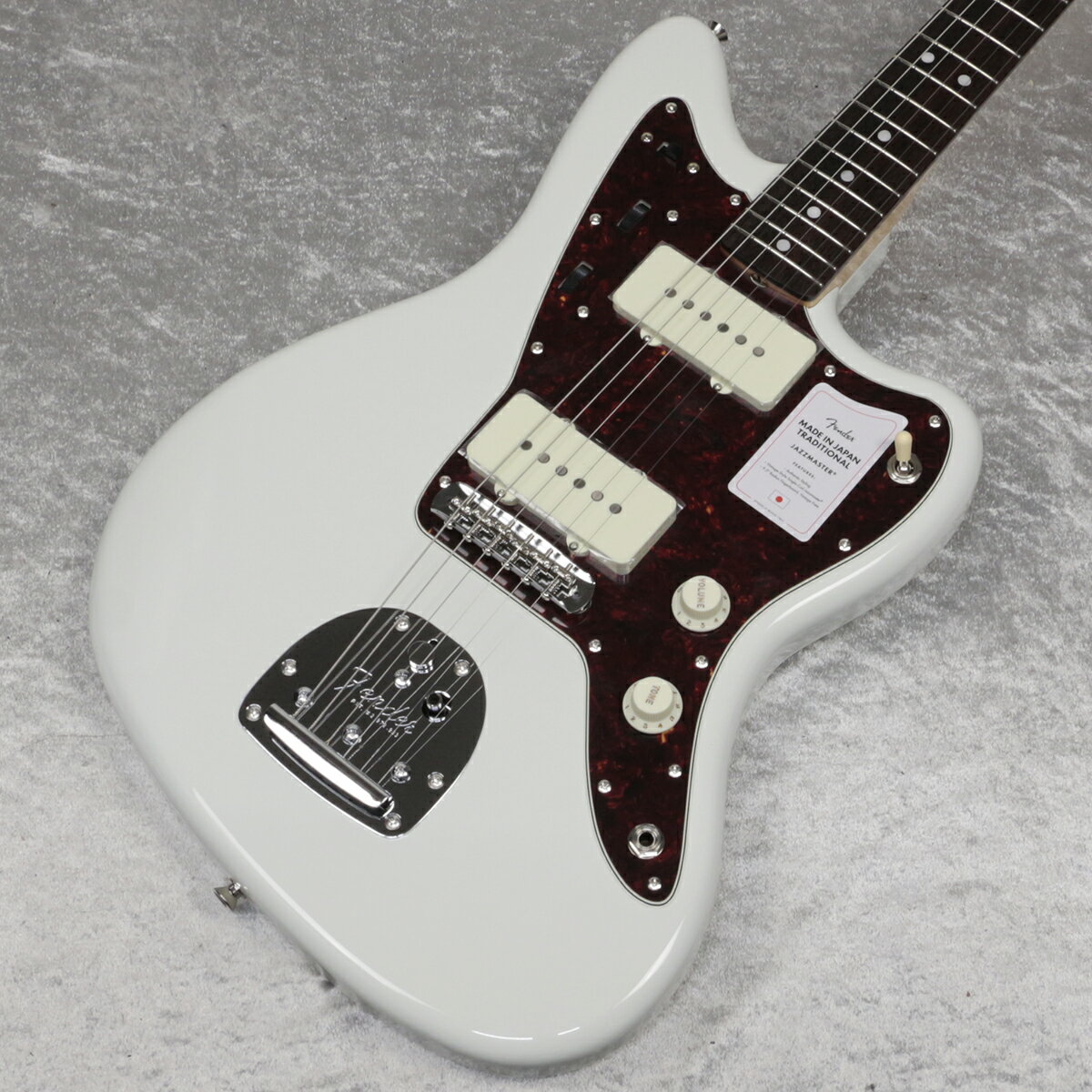 日本製フェンダーの大人気シリーズ『Made in Japan Traditional』がリニューアルして登場！！ ~60s Jazzmaster~ フェンダーの伝統的な楽器製作の美学と日本の洗練されたクラフトマンシップを融合することで導き出されたMade in Japan Traditionalシリーズ。 フェンダーの正統なDNAが、確かなMade in Japanクオリティで蘇ります。 Made in Japan Traditional 60s Jazzmasterはグロスフィニッシュのバスウッドボディを採用。 21本のヴィンテージスタイルフレットを装備した9.5インチラジアスの”U” シェイプメイプルネックがTraditionalシリーズならではのクラシカルな演奏性を提供します。 フローティングトレモロテイルピース付きの6サドル式ヴィンテージスタイルブリッジ、そしてTraditionalシリーズのために選定されたオリジナルピックアップはリアルで音楽的なヴィンテージトーンを奏でます。 細めに設計されたナット幅は日本のプレイヤ ーにも弾きやすい仕様となっています。 堅実なギタークラフトマンシップと、プレイヤーのニーズに柔軟に対応する答えが、本シリーズに反映されています。 主な仕様 ボディ Basswood ボディフィニッシュ Gloss Polyester ボディシェイプ Jazzmaster ネック Maple ネックフィニッシュ Gloss Urethane ネックシェイプ "U" Shape スケール 25.5" (648 mm) フィンガーボード Rosewood フィンガーボードラジアス 9.5" (241 mm) フレットナンバー 21 フレットサイズ Vintage ナット Bone ナット幅 1.615" (41.02 mm) ポジションインレイ White Dot ブリッジピックアップ Vintage-Style Single-Coil Jazzmaster ネックピックアップ Vintage-Style Single-Coil Jazzmaster コントロール Lead Circuit Controls (Slide Switch Down): Volume (Neck), Volume (Bridge), Master Tone; Rhythm Circuit Controls (Slide Switch Up): Two Thumbwheel Controls for Neck Pickup Volume and Tone ピックアップスイッチ 3-Position Toggle: Position 1. Bridge Pickup, Position 2. Bridge and Neck Pickups, Position 3. Neck Pickup ピックアップコンフィギュレーション SS ブリッジ 6-Saddle Vintage-Style Adjustable with “Floating” Tremolo Tailpiece ハードウェアフィニッシュ Nickel/Chrome チューニングマシーン Chrome Die-Cast ピックガード 4-Ply Tortoiseshell コントロールノブ Aged White ストリング Nickel Plated Steel (.009-.042 Gauges) ケース/ギグバッグ Gig Bag ■付属品：ソフトケース、メーカー保証書、トレモロアーム ■保証:2年 ■JANコード:0885978483464 ※画像はサンプルです。