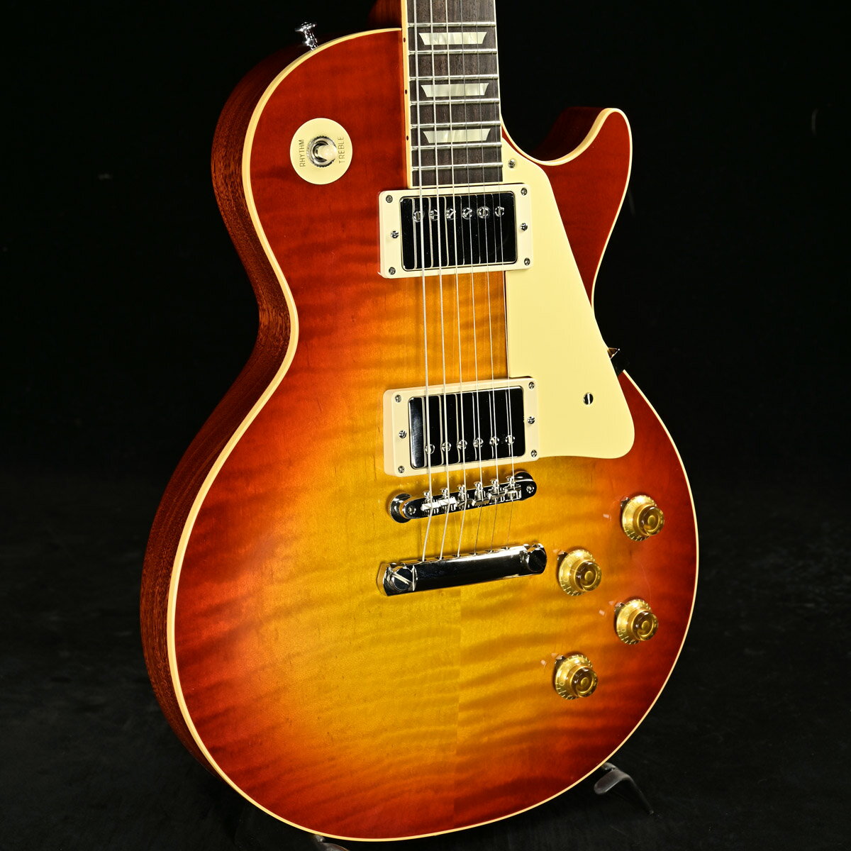 Glossフィニッシュ採用の1959LP！店頭展示処分！OUTLET特価！キルト掛かった揺らぎを持つフィギュアドトップにGlossフィニッシュの『Factory Burst』が見事にマッチング。外周へグラデーションするチェリーが鮮やかなファクトリーバーストは退色のない工場出荷時のカラーを再現しており、59グレードらしい高級感を押し上げています。ネックシェイプは、レスポールの中でも最も愛されている59年特有の、細すぎず、太すぎない人気のAuthentic '59 Medium C-Shapeにロールドバインディングを合わせ、手馴染みの良いグリップ感を再現しております。PUは名器『Custom Bucker Alnico III』を搭載。タイトな低域にスムースな高域でリフプレイでも、もたつきを感じさせない即応性で意外とハードドライヴィンなサウンドでもイケており、2013年以降のヒスコレの高評価を決定付けた一つの要素を持つベストなチョイスともいえます。エイジングされていない、ピュアな59LPをお探しの方も多かったのではないでしょうか?ネックフィーリングもすこぶる良く、多くのヴィンテージ系プレイヤーを唸らせる仕上がり。過去のモデルが高騰している昨今ですが、実は新品が狙い目!オススメの一本ですよ!■S/N:933310■Weights:3.94kg■付属品:認定証、ユーザー登録証、純正ハードケース 製品仕様 Body Top 2-Piece Figured Maple, Hide Glue FitBody Back MahoganyNeck MahoganyNeck Profile Authentic 59 Medium C-ShapeFingerboard Dark Indian Rosewood, Hide Glue FitNut NylonBridge No-Wire ABR-1Tailpiece Light Weight Aluminum Stop TailpieceTuning Keys Kluson Single Line, Single RingRhythm Pickup Custombucker &#40;Unpotted&#41;Lead Pickup Custombucker &#40;Unpotted&#41;Controls CTS 500K Audio Taper Potentiometers, Paper-in-Oil Capacitors　