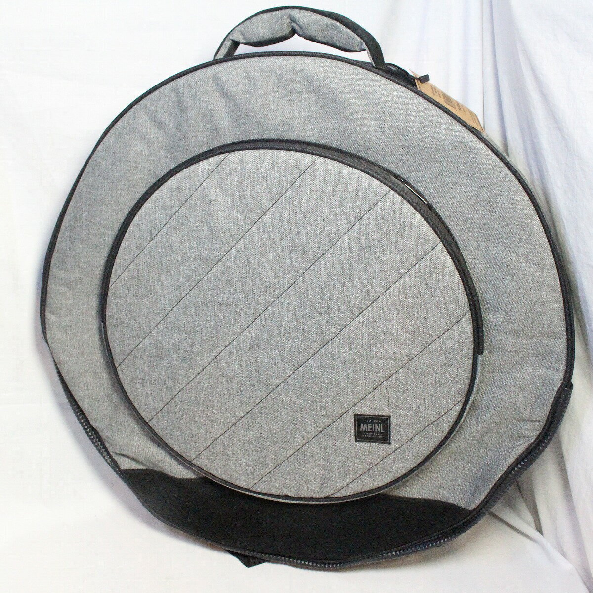 ツアーバッグとしてのタフな使い勝手を重視し、耐久性の高い600Dポリエステルを生地に採用したシンバルバッグ。 底面にはスウェードで補強をしており、クラシカルながらデザイン性の高い仕上げとなっております。 メインコンパートメントは最大22インチシンバルを収納可能なサイズで、 3枚のシンバルディバイダーが入っており、底面外部はスウェード生地によって補強されています。 フロントコンパートメントは15インチシンバルまで収納可能で、シンバルディバイダーが1枚入っています。 キャリーストラップはバックパック式を採用したリュックタイプです。 収容力の目安：ハイハット1ペア、クラッシュx3、ライドx1程度 カラー：Heather Gray