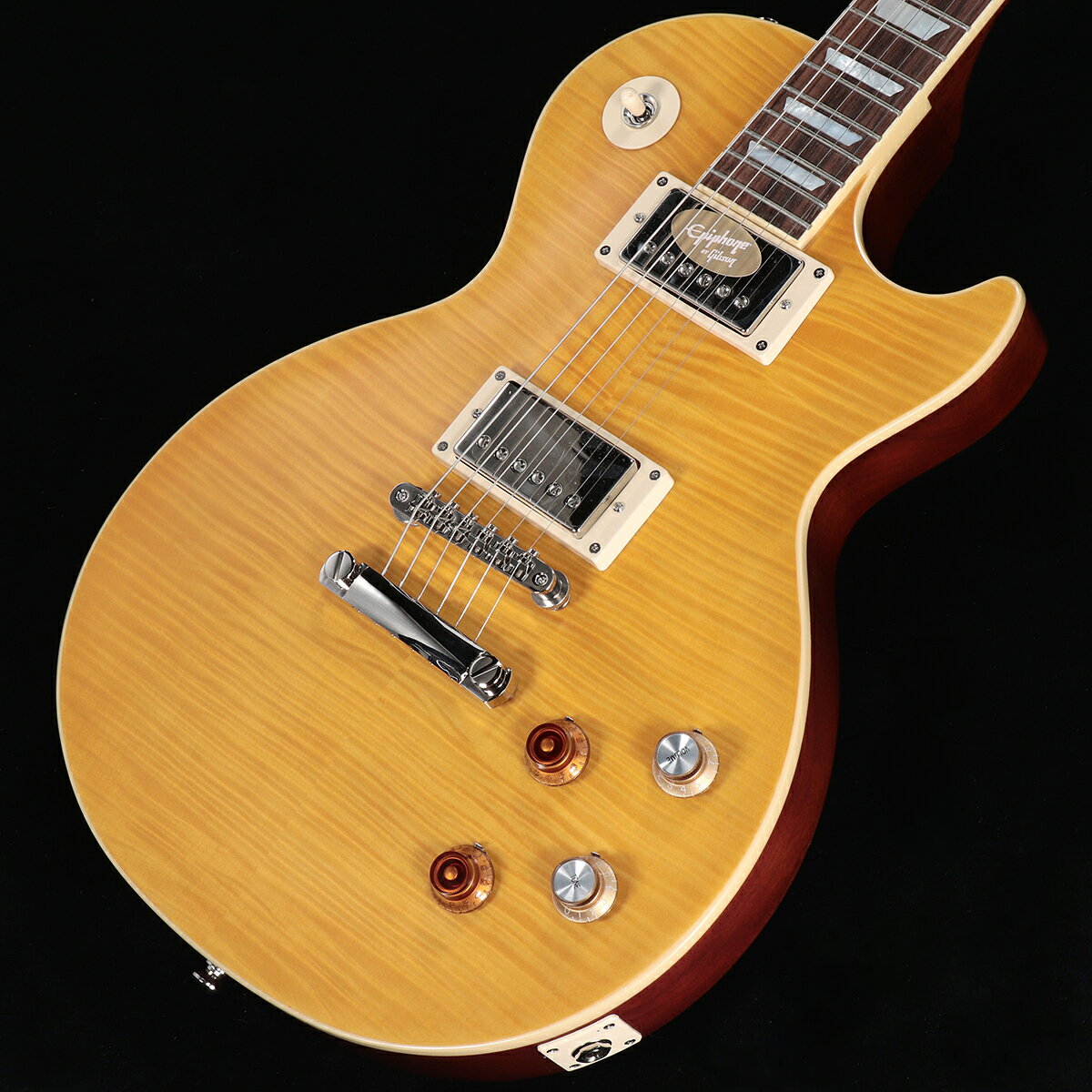 Epiphone Inspired by Gibson Custom Shopから、遂にあの"Greeny"がリリース！Custom ShopからリリースされたKirk Hammett "Greeny" 1959 Les Paul Standard Murphy Lab Aged、USAからリリースされたKirk Hammett "Greeny" Les Paul Standardが記憶に新しいですが、ついにEpiphone(Inspired by Gibson Custom Shop)ブランドからもあの伝説的なレス・ポールを再現したモデルがリリース！今回リリースされたEpiphone Kirk Hammett "Greeny" 1959 Les Paul Standardは、エピフォンとギブソン・カスタム・ショップの緊密なコラボレーションにより開発されました。カーク・ハメットが愛用している伝説的なオリジナル"Greeny"にインスパイアされ、オリジナル同様に特徴的なスペックを備えております。USA製モデルと同じGibson USA Greenybuckerピックアップを搭載し、勿論ネックピックアップは反転されております。ネックシェイプもCustom Greeny Profileを採用し、さらにリア側のリフレクターノブ、"Spade"ボタンGroverペグなどオリジナルを忠実に再現しております。そして特筆すべきはヘッドストックシェイプです。遂にEpiphoneのコアモデルでもGibsonオリジナルの“openbook”ヘッドストックを採用されることとなり、Epiphone Kirk Hammett "Greeny" 1959 Les Paul Standardがその最初のモデルとなります。その他にもGibson Custom Shopとのコラボレーションモデルに相応しく、Switchcraft製ピックアップ・セレクターとアウトプット・ジャック、CTS製ポテンショメーター、Mallory製コンデンサーなど、プレミアムなパーツを採用しています。ルックスだけでなくサウンド、プレイフィールに於いても、あの伝説的ギター”Greeny”の"魔法"のような魅力を体験することができる、Epiphoneブランド最高峰に位置するモデルです。EpiphoneとGibson Custom Shopのコラボーレションロゴの入ったヴィンテージスタイルのハードシェル・ケースが付属します。■S/N:23051526883■重量:4.00kg■JANコード:4570155996528■付属品:ハードケース、Epiphoneユーザー登録カード ※ご購入後、同梱されるユーザー登録カードに必要事項をご記入の上、15日以内にギブソン・ジャパンへご郵送ください。ユーザー登録したご本人様に限り、メーカー規定の故障に対して保証が提供されます。 製品仕様 Body ShapeLes PaulBody MaterialMahoganyBody TopMaple with AAA Flame Maple VeneerNeckOne Piece MahoganyProfileCustom Greeny ProfileNut width43mmFingerboardIndian LaurelScale length628.65mmNumber of frets22NutGraph TechInlayMother of Pearl TrapezoidBridgeEpiphone ABRTailpieceLockTone Stop BarTunersGrover Rotomatic with Kidney ButtonsPlatingNickelNeck pickupGibson USA Greenybucker with Reversed Magnetic Polarity;Reverse MountedBridge pickupGibson USA GreenybuckerControls2Volume, 2Tone, 50s Wiring, CTS Potentiomenters, Mallory CapacitorsCaseVintage-style Hardshell with Tan Exterior, Pink Interior, and Custom Artwork