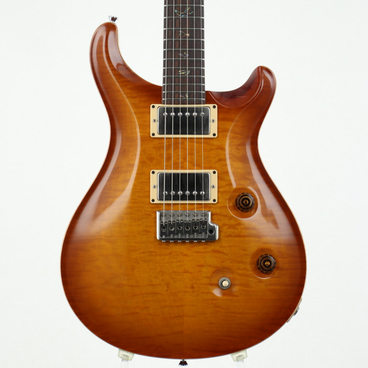 全世界350本限定1957/2008リミテッドPRSファクトリーにて開催された『Experience PRS 2008』にて発表された、全世界350本限定1957/2008リミテッドが入荷しました！軽量なマホガニーボディのトップ材に選ばれた10TOPグレードの2Pキルトメイプルは、柔らかな雰囲気のサンバーストと、その奥からヴィンテージフィールを漂わせる杢並びが秀逸。ローズ指板貼りのマホガニーネック、ノンストレスなグリップ感とレスポンスに優れたWide Thinネックカーブ、25inchスケール、24フレットといったCustom24の定番スペック。そしておなじみのバードインレイは鳥の輪郭を捉えたデザインのPaua Rim 'J' Birdsを採用。そして今回のキモであるピックアップには、大変価値のあるワイヤーを用いて開発された『57/08』を搭載。マイルドでありながら気持ちのいい煌びやかなハイの余韻を残すPRSらしいパワフルさ、ピッキングの強弱を忠実に反映させる枯れたニュアンスを感じられる、”現代版PAFピックアップ”サウンドに仕上がっております！コントロールもVol、Tone、トグルセレクターとシンプルなレイアウトで、ToneポットのPush/Pullでコイルタップが可能。モダンとヴィンテージを見事に掛け合わせたPRSの解釈が実に見事な1本！是非その手にとってお確かめ下さい！入荷時よりストラップピンが交換されております。リペアショップにて全体クリーニング、全体セットアップが行われております。ボディにはピックアップ間に弾き傷、裏側右下エッジ部分に小さい打痕が入っておりますが、光に当てて認識できるものやパッと見ではほとんど目立たないダメージばかりです。裏コントロールパネルのサインがほとんど消えております。ハードウェアには多少のくすみこそ見られますが、比較的キレイに磨かれており、動作問題も現状ございません。【ネックコンディション】現状大きな問題なし【トラスロッド】両方向余裕あり【フレット残り】残り8割ほど【12F上の弦高】6弦側:約2.0mm 1弦側:約1.5mm【生産国】USA【ケース】純正ハードケース【付属品】 アーム、バードタグ(スペックカード)■商品ランク:B+：多少傷はあるが通常使用する用途において問題なし■シリアルナンバー:143050■重量:3.52kg■保証:12ヶ月