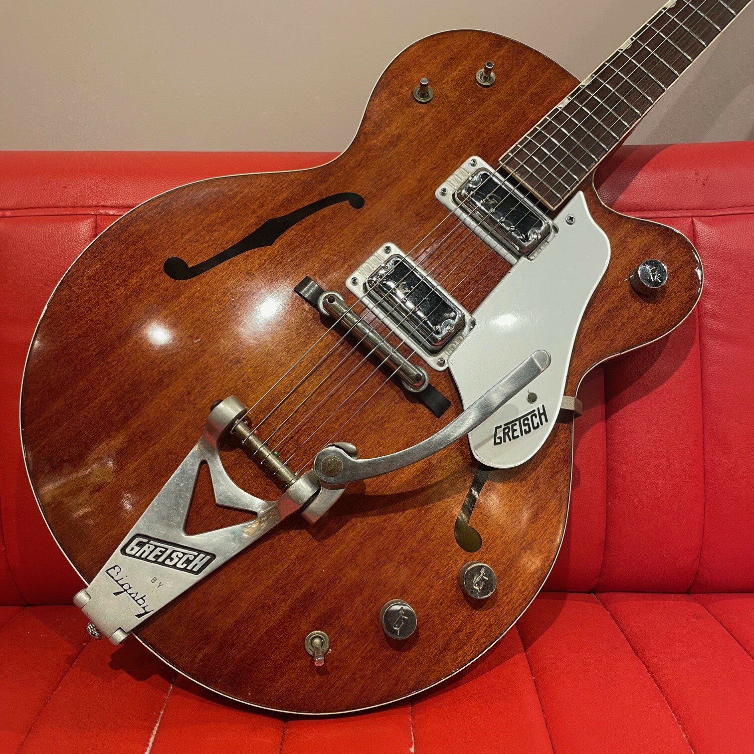 1962年製のGretsch #6119 Chet Atkins Tennesseanが入荷致しました。 細かく仕様変更が行われるテネシアンですが、本機は薄めのボディにヘッド先端のシリアル刻印、縁取りなしのシミュレイテッドFホール、0フレットなど、2ピックアップ仕様となる1961年以降では、比較的初期のスペックが特徴となります。 電装系に交換点がございますが、オリジナル度の高い一本。 オリジナルのハイロートロン・ピックアップによるメロウなサウンドからトゥワンギーなトーンが味わえます。 オールドのGretschにはつきものですが、ネック、ボディ共にバインディングの劣化が見受けられます。 ポット(×3)、セレクター・スイッチ(×1)交換あり。 オリジナルのポット(1962年デイト)とセレクター・スイッチも付属致します。 Serial Number：X7721 Weight：3.1kg With Original Hard Case(ハンドル破損、表面に英字の書き込みあり)