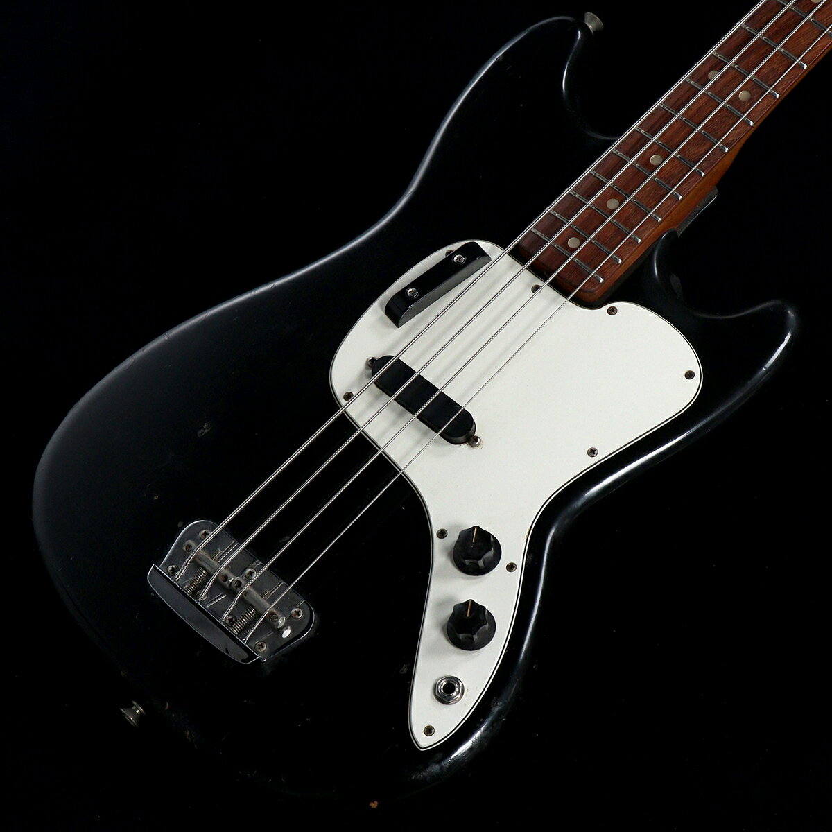 1975年製のMusicmaster Bassが入荷致しました!!ショートスケールベースのスチューデントモデルとして発売されたミュージックマスターベース。兄貴分といえるムスタングベースと比較してシンプルな仕様ではありますが、独特のシェイプのピックガードやチューナーがこのモデルならでは。シリアルナンバーは695288、ネックデイトは0700-3651であることから75年製と判断しております。ピックアップはグレイボビンでコイルは巻き直しが行われております。POTは現在近年ものに変更されておりますが、元のPOT（75年製）も付属しております。コンデンサはオリジナルが流用されています。フィンガーレスト・ネジは近年ものに交換されています。年式ゆえのの使用感はございますが、パワーはあまりありませんが、TONEを絞ってあげると適度にまとまったサウンドとなって楽しいです。是非お試しくださいませ。■商品ランク: B+：多少傷はあるが通常使用する用途において問題なし■製造年:1975■保証:12ヶ月■シリアルナンバー:695288■ケース：ソフトケース/非純正■重量:3.18kg■フレット残り:80%程度■トラスロッド:締め/緩め方向に余裕あり■ネックコンディション:問題無し■説明書:-■他付属品:-■備考：その他付属品は画像に写っているもののみとなります。