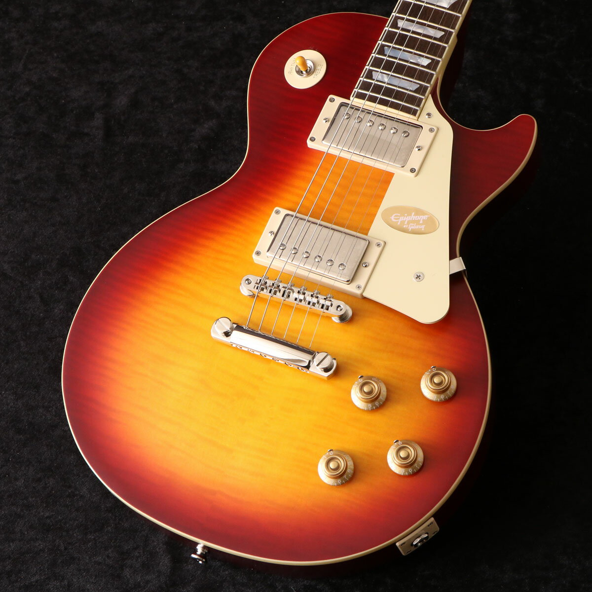 Epiphone Inspired by Gibson Custom Shopから1959 Les Paul Standardがリリース！ EpiphoneとGibson Custom Shopのコラボレーションによって製作されるEpiphone Inspired by Gibson Custom Shopのラインナップが大幅に刷新されました。 既にリリースされている1958 Korina Flying V/Explorer、1963 Firebird I/Vに加えて、 今回Les Paul Standard、SG Custom、ES-355、Les Paul CustomといったGibsonを代表するモデル群が新たにリリースされます。 エピフォンはギブソン・カスタム・ショップとのコラボレーションにより、希少なヴィンテージクラシックを見事に再現した1959 Les Paul Standardをリリースします。 1959 Les Paul Standardは、マホガニーBodyにAAAフレイム・メイプル・ベニアのメイプルTop、1959スタイルを踏襲した丸みを帯びたミディアムCプロファイルの1ピース・マホガニー・ネック、ジョイントはロング・ネック・テノン（ディープジョイント）を採用。 ヘッドストックはGibsonオリジナルの“openbook”ヘッドストック・シェイプが採用され、エイジドMOPロゴ、チューナーやピックガード、バインディングもヴィンテージスタイルが再現されています。 ピックアップにはCustom Shop製品にも採用されているGibson Custombuckerをマウント。 さらに50sワイヤリング、CTSポテンショメーター、Malloryコンデンサー、Switchcraftセレクタースイッチとアウトプットジャック、も採用され、サウンド面においても充実のスペックを誇ります。 ヴィンテージスタイルのInspired by Gibson Customロゴ入りのハードシェル・ケースが付属いたします。 エピフォンとギブソン・カスタム・ショップのコラボレーションは、紛れもなく、親しみやすく、高品質なギターを生み出し続けています。 真正性、ルックス、トーン、フィーリングをさらに高めた新しいEpiphone Inspired by Gibson Custom 1959 Les Paul Standard はたゆまぬ探求における数十年の努力の集大成でもあります。 ■付属品：ハードケース、ユーザー登録カード ※ご購入後、同梱されるユーザー登録カードに必要事項をご記入の上、15日以内にギブソン・ジャパンへご郵送ください。ユーザー登録したご本人様に限り、メーカー規定の故障に対して保証が提供されます。 ■シリアルナンバー:23121524529 ■重量（kg）:3.87 S:新品 製品仕様 Shape Les PaulMaterial MahoganyTop Maple with AAA Flame Maple VeneerFinish VOS Vintage Original SheenWeight Relief N/ABinding Single Ply, Top and FretboardNeck One Piece MahoganyNeck Profile 1959 Rounded Medium CNut width 43mmFingerboard LaurelScale length 628.65mmNumber of frets 22Nut Graph TechInlay Mother of Pearl TrapezoidBridge ABR-1Tailpiece Gibson Historic Reissue Stop BarTuners Epiphone Deluxe with Keystone ButtonsPlating NickelNeck pickup Gibson CustombuckerBridge pickup Gibson CustombuckerControls 2 Volume, 2 Tone; CTS Potentiometers and Mallory Capacitors, 50s WiringCase Brown Hardshell with Pink Interior, Gold Hardware, and Inspired by Gibson Custom Logo