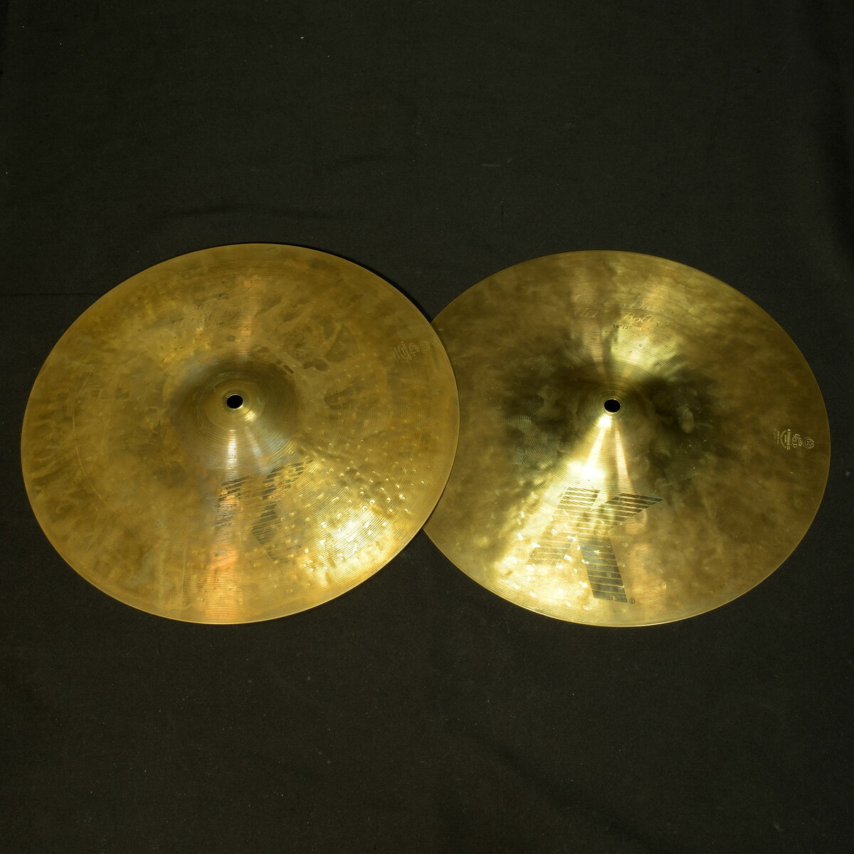 Zildjianの「K.Custom 14 Dark Hihats Top&Bottom」です。Kジルジャンをより個性的にアレンジしたシリーズで、多様化するサウンドニーズに応えオーバー・ハンマリング＆多様なレイジングを採用し個性的な表現力を持つハイハットシンバルのセットです。繰り返しのハンマリングからくる、枯れながら深みのある倍音。サウンドに深みのある使い易いハイハットシンバルセットです。実測重量：Top:1.06kg/Bottom:1.21kgくすみ等使用感がありますが割れなどはございません商品ランク:B+ （良品）保証　：　無し付属品　： 本体のみ　 重量　：　Top:1.06kg/Bottom:1.21kgシリアル　：　無し