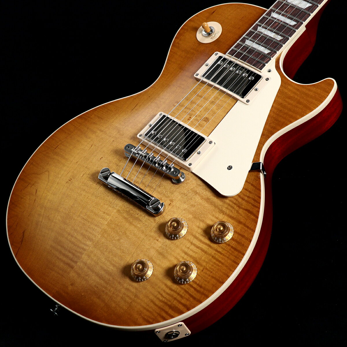 当社オーダーのLes Paul Standard 50s Figured Top！オーダー考案から約1年・・・遂にイシバシ楽器エクスクルーシヴモデルが完成いたしました。Gibson USAラインナップのなかでトップセールスを誇るLes Paul Standard 50s Figured Topをベースに、ボディTopカラーを「Dirty Lemon Burst」に、ボディ＆ネックBackを「Vintage Cherry」に変更してオーダーいたしました。「Dirty Lemon Burst」は、Gibson USA現行ラインナップにはない特注カラーで、昨年までに展開されていたUSエクスクルーシヴモデルでも採用されておりました。Gibson Custom Shopのヒストリックモデルでも採用されることの多いレモン系カラーは、リアルヴィンテージで見られるチェリーが経年変化によって褪色した風合い・色味を再現した非常に人気の高いカラーです。今回その人気の高いレモン系カラー「Dirty Lemon Burst」に加え、さらにルックスの完成度を高めるためにボディBackとネックBackに明るすぎない「Vintage Cherry」を採用いたしました。このカラーマッチングによりGibson Custom Shopヒストリックモデルさながらのヴィンテージ感あふれるルックスのレスポール・スタンダードが完成いたしました。■Gibson USA Les Paul Standard 50sAAグレード・メイプル・トップにウエイトリリーフを廃したマホガニー・ボディ、50年代の丸みを帯びたラウンド・ネックを採用した往年のレスポールスタンダードを求めるプレイヤーに最適な一本です。ピックアップには定評のあるBurstbucker 1(Neck)/Burstbucker 2(Bridge)を搭載し、左手の細かなニュアンスやピッキングの強弱、繊細なボリュームコントロールといった演奏表現を余さず出力します。近年のギブソンに見られる基盤でなく、ハンドワイヤードの電装にはオレンジドロップキャパシターを搭載。キーストーンペグ、ワイヤーなしのABRブリッジにアルミニウム製ブリッジ・テイルピースなど、サウンド面・ルックス面においてヴィンテージを意識した拘りが満載です。※ご購入後、同梱されるユーザー登録カードに必要事項をご記入の上、15日以内にギブソン・ジャパンへご郵送下さい。ユーザー登録したご本人に限り、メーカー規定の故障に対して保証が提供されます。■S/N:214540281■重量:4.36kg■JANコード:4570156005977■付属品:ハードケース、ユーザー登録カード 製品仕様 Body Shape Les PaulBody Material MahoganyTop AA Figured MapleBinding Single-ply Top and FretboardBody Finish Gloss Nitrocellulose LacquerWeight Relief NoneNeck Material MahoganyProfile 50s VintageScale Length 628.65 mm / 24.75 inFingerboard Material Indian RosewoodFingerboard Radius 304.8 mm / 12 inFret Count 22Frets Medium JumboNut Material Graph TechNut Width 43.05 mm / 1.694 inInlays Acrylic TrapezoidJoint Glued In, Set NeckHardware Finish NickelBridge ABR-1 Tune-O-MaticTailpiece Aluminum Stop BarTuning Machines Vintage Deluxe with Keystone ButtonsPickguard CreamControl Knobs Gold Top Hat with Dial PointerSwitch Tip AmberNeck Pickup Burstbucker 1Bridge Pickup Burstbucker 2Controls 2 Volume, 2 Tone; Hand-wired with Orange Drop CapacitorsPickup Selector 3-way ToggleCase Hardshell Case