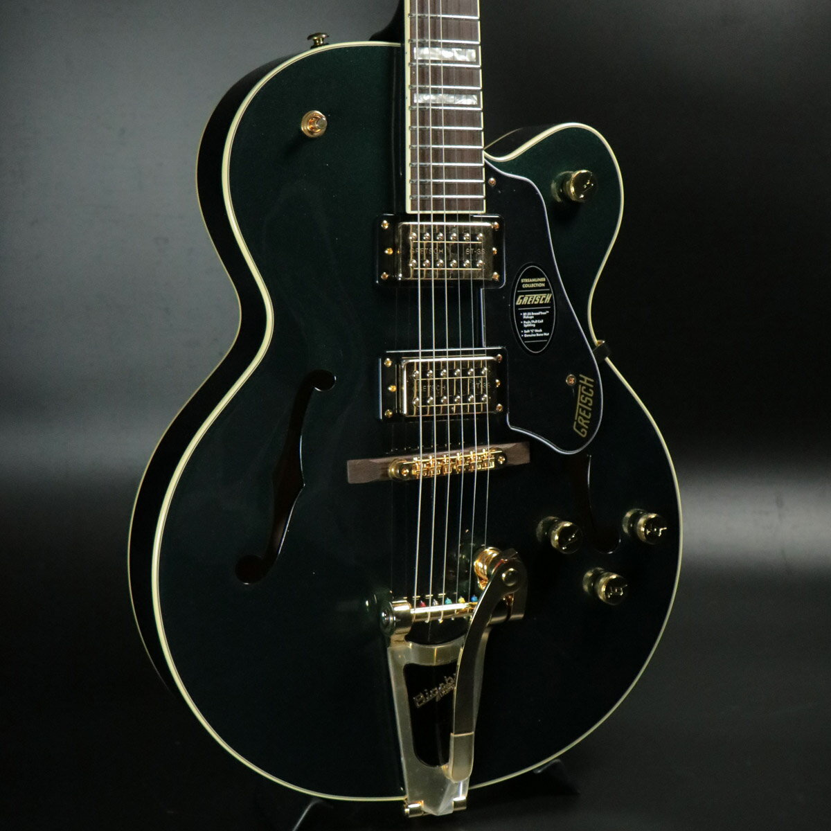 キャデラックグリーンにゴールドパーツが輝く限定モデル!店頭展示処分！OUTLET特価！Streamliner Collectionは、Gretschギターの輝かしい過去の要素を再訪し、エキサイティングな新機能と組み合わせることで、優れたパフォーマンス、サウンド、スタイルを驚くべき価値で提供します。エレガントなゴールドハードウェア、メタル”Gアロー”コントロールノブ、パーロイド”Big Block”インレイを採用したG2420TGは、モダンなサウンド、最新のエレクトロニクス、正真正銘のエレガントなスタイリングをフィーチャーし、”That Great Gretsch Sound!”を体現する、大胆なプレイヤーの欲求を満たすギターです。主な特徴・ Broad’Tron BT-3Sハムバッカー・ リッチで深いレゾナンスのフルボディサウンドを実現するフルホロウのアーチドメイプルボディ・ Soft “C”シェイプナトーネック・ 22本のジャンボフレットとパーロイド”Big Block”インレイを配した12インチラジアスローレル指板・ ボーンナット・ マスターボリューム、マスタートーン、ピックアップ毎の個別ボリュームコントロール・ プッシュ／プル式コイルスプリット機能付きマスターボリューム・ メタル”Gアロー”コントロールノブ・ 固定ローレルベース付きAdjusto-Maticブリッジ・ Bigsby B60ヴィブラートテイルピース・ 3-plyブラックピックガード・ ゴールドハードウェア■シリアルナンバー:IS250505932■重量:3.22kg■付属品：ギグケース、正規保証 製品仕様 Body Material Laminated MapleBody Finish GlossNeck Nato, Soft “C”Neck Finish GlossFingerboard Laurel, 12” &#40;305 mm&#41;Frets 22, Medium JumboPosition Inlays Pearloid Big BlockNut &#40;Material/Width&#41; Bone, 1.6875” &#40;42.86 mm&#41;Tuning Machines Die-Cast SealedScale Length 24.75” &#40;629 mm&#41;Bridge Adjusto-Matic with Secured Laurel BasePickguard 3-Ply BlackPickups Broad’Tron BT-3S &#40;Bridge&#41;, &#40;Middle&#41;, Broad’Tron BT-3S &#40;Neck&#41;Pickup Switching 3-Position ToggleAuxiliary Switching Push/Pull Pot &#40;for Coil Split&#41;Controls Volume 1. &#40;Neck Pickup&#41;, Volume 2. &#40;Bridge Pickup&#41;, Master Volume, Master Tone