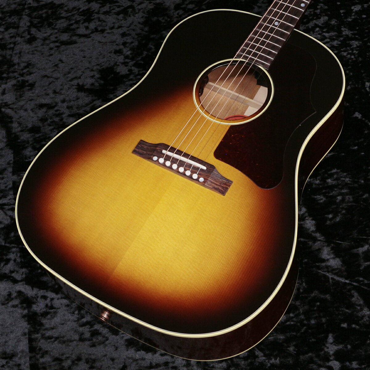 人気の50sスタイルのJ-45！J-35の後継機種として1942年に誕生した、ラウンドショルダー・アコースティックギターの「J-45」。現在に至るまで多くのミュージシャン・ギタリストに愛され続けてきたモデルで、"The Workhorse"という異名を持ちます。当時45ドルで発売されていたことでこのネーミングになりました。オリジナルJ-45は誕生から28年間ラウンドショルダーの代表格として君臨していました。しかし、1970年に変革期を迎え、スクエアショルダー＆ロングスケールへと変貌を遂げます。1982年に生産完了となりますが、1984年に待望の「ラウンドショルダー＆24-3/4インチスケール」として復活します。こちらは、2020年に新たにナインラップに加わった「オリジナル・コレクション」のJ-45 Original です。USA、モンタナ工場製、新品、正規輸入品です。隠れた人気を誇る1950sシリーズを受け継いだモデルで、ラージピックガードを装着。Bodyはオール単板で、シトカ・スプルースTop、マホガニーSide/BackのJ-45王道スペック。スキャロップドXブレーシングを施し、シングルリングロゼッタを纏っています。ストレートサドルを採用し、ギブソンスケールのマホガニーNeckは馴染みのあるラウンドプロファイル。ペグは3連クルーソンタイプを採用し、ピックアップはL.R.BaggsのVTCを搭載し、サウンドホールエッジ部でVolume/Toneコントロールが可能です。ニトロセルロースラッカーフィニッシュ（グロス）、にかわ接着のダブテイルNeckジョイントはお馴染みの仕様です。往年の名器と呼ばれる所以が分かる王道のJ-45サウンド！ミッドレンジ豊かで腰があり、ラウドに奏でてくれます！※2021年製造からネックヒールのストラップピンは同梱となり、出荷時に取付けられておりません。※お届けにお時間を要する場合には別途お知らせいたします。ご購入後、同梱されるユーザー登録カードに必要事項をご記入の上、ギブソン・ジャパンへご郵送ください。ユーザー登録したご本人様に限り、メーカー規定の故障に対して無期限での保証が提供されます。 ■JANコード:4580568415592■付属品:ハードケース、Gibsonユーザー登録カード 製品仕様 Body ShapeJ-45Body TopSitka spruceBody BackMahoganyBody SideMahoganyBracingTraditional hand scalloped X-bracingBindingMulti-ply Top, single-ply BackFinishNitrocelluloseNeck MaterialMahoganyProfileRoundScale Length24.75" / 628.65mmFingerboard MaterialRosewoodFingerboard Radius12"Number Of Frets20FretsStandardNut MaterialBoneNut Width1.725" / 43.81mmInlaysMother-of-pearl dotsJointCompound Dovetail Neck-to-bodyTuner PlatingNickelBridgeTraditional belly upSaddle MaterialBoneTuning MachinesGrover Strap Cream ButtonPickguard50&#39;s, TortoiseTruss Rod CoverBlackBridge PinsTusqUnder Saddle PickupLR Baggs VTCControlsVolume and Tone