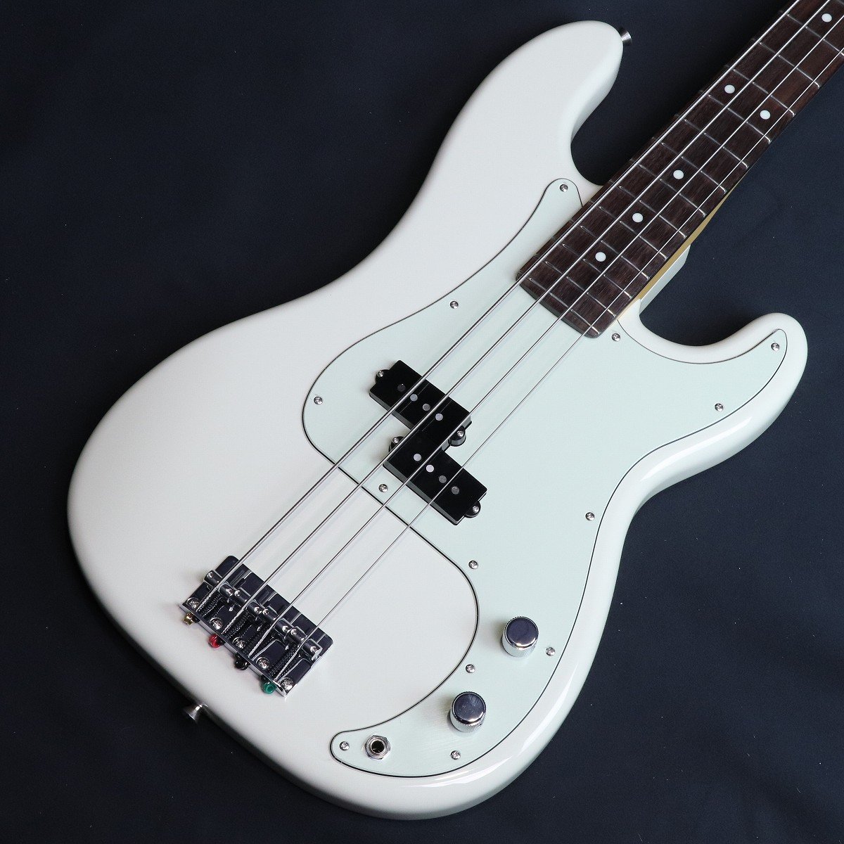 イシバシ限定販売！機材マニアの先輩も納得？！の仕様！ISHIBASHI FSR Hybrid II P-BASS RW OWH W/Seymour Duncan”SPB-1登場！日本製ではありそうで現行ラインナップにない、オリンピック・ホワイト(Olympic White)にミントグリーン・ピックガードの日本製ハイブリッドIIプレシジョン・ベースです。現行のフェンダー日本製ベースでは、 HAMA OKAMOTO PRECISION BASS OWHに使用されるこのカラーは若干黄色みがかったVintage Whiteと真っ白なArctic Whiteの中間色の様なややクリーム色の様な落ちついたホワイトです。 American Professional II P-BASSには採用されているカラーです。3-Ply Mint Greenピックガードとの相性も抜群です。 21フレット仕様ツバ出しネックエンド、ネック上部からトラスロッド調整可能です。ネック裏にスカンク・ストライプもあるModern "C"シェイプのネックは丸みを帯びた形状で握り込みやすく、サテン仕上げのネック裏は滑りが良く、運指し易いネックです。ベースの心臓部ピックアップにはなんと”Seymour Duncan”SPB-1(Vintage P-Bass)を敢えてロゴ無しカバーで搭載！（さり気なくカスタマイズしている感を演出している所もこだわりポイントです。） ”Seymour Duncan”SPB-1(Vintage P-Bass)ピックアップは ALNICO 5マグネットにより、ヴィンテージのウォームでアタック音が滑らかなトーンを忠実に再現したピックアップです。Low-MIDに芯のあるサウンドでバンドの中でも埋もれないサウンドです。そしてTONEノブを引っ張ってみて下さい。シリーズ/パラレル切り替えスイッチになっており、音色が劇的に変化します。 シリーズのコシのある太くウォームなサウンドから一変しパラレルだとクリアな高域と繊細で表現力のあるサウンド、いわゆるジャズベースのサウンドに近いサウンドに変化致します。トーンによってももちろん変化しパラレルのトーン絞り気味のサウンド等はまさにヴィンテージジャズベースの様なサウンドがお楽しみ頂けます。 是非通常の日本製HybridIIと比較して頂いてサウンドの違いを体感して見て下さい。こだわりの詰まった渾身のプレシジョンベース イシバシ楽器完全限定販売となります。是非お早目にご検討下さい。 ■付属品：ソフトケース、調整用レンチ、メーカー正規保証書（2年） ■JANコード:0717669977412 ■シリアルナンバー:JD25014529 ■重量:3.88kg ※こちらの商品は店頭展示品の為、画像に写りにくい磨き傷などがある場合がございます。 製品仕様 ColorOlympic WhiteBodyAlderNeck MapleNeck FinishSatin Urethane Finish on Back, Gloss Urethane Finish on FrontNeck ShapeModern "C"Scale34" &#40;86.36 cm&#41;Fingerboard RosewoodFingerboard Radius9.5" &#40;241 mm&#41;Flet number21Flet SizeNarrow TallNutBoneNut Size &#40;mm&#41;1.650" &#40;42 mm&#41;Position InlayIvory DotsMiddle Pickup SEYMOUR DUNCAN SPB-1ControlMaster Volume, Master Tone with Push-Pull Switch &#40;Series / Parallel&#41;Bridge4-Saddle Vintage-StyleHardware FinishChromeTuning MachineVintage-StylePickguard3-Ply Mint GreenPickup CoverBlackControl KnobKnurled Flat-TopString45-105