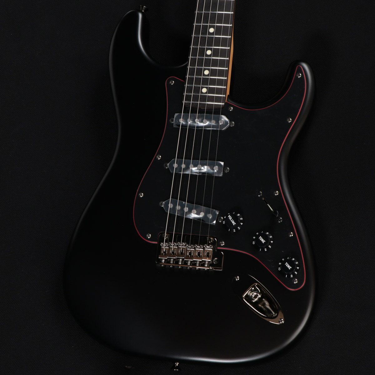 黒と赤を基調とした『Noir』シリーズが限定生産にて待望の復活！ Made in Japan Limited Hybrid II Stratocaster, Noirは、フランス語で黒を表す””Noir””をモデル名に採用した、黒と赤を基調とした力強いルックスの製品です。 目を引くレッドのセンターレイヤーを纏った3-Plyブラックピックガードを搭載しており、ヘッドのレッドメタルロゴと相まって独特な雰囲気を醸し出します。 金属パーツやプラスチックパーツは全てブラックで統一しており、ナットもSyntheticBoneを搭載。よりヘビーな見た目に仕上げています。 ベースとなっている、Hybrid II Stratocasterは、定評あるアルダーボディにHybrid II Custom Voiced Single Coilピックアップを装備し、ヴィンテージスタイルサドル付きの2点支持トレモロシステムを搭載。 ヴィンテージロッキングチューナー、Modern “C”シェイプにサテンフィニッシュのネック、9.5インチラジアスの指板とナロートールフレットがスムーズなプレイヤビリティを提供します。 ※本製品は2025年の限定生産品です。 主な仕様 Body Material : Alder Body Finish : Satin Urethane Neck : Maple, Modern “C” Neck Finish : Satin Urethane Fingerboard : Rosewood, 9.5” (241 mm) Frets : 22, Narrow Tall Position Inlays : White Dot (Rosewood) Nut (Material/Width) : Synthetic Bone, 1.650” (42 mm) Tuning Machines : Vintage-Style Locking Scale Length : 25.5” (64.77 cm) Bridge : 2-Point Synchronized Tremolo with Vintage-Style Stamped Steel Saddles Pickguard : 3-Ply Black/Red/Black Pickups : Hybrid II Custom Voiced Single Coil Stratocaster (Bridge), Hybrid II Custom Voiced Single Coil Stratocaster (Middle), Hybrid II Custom Voiced Single Coil Stratocaster (Neck) Pickup Switching : 5-Position Blade : Position 1. Bridge Pickup, Position 2. Bridge and Middle Pickup, Position 3. Middle Pickup, Position 4. Middle and Neck Pickup, Position 5. Neck Pickup Controls : Master Volume, Tone 1. (Neck Pickup), Tone 2. (Bridge/Middle Pickup) Control Knobs : Black Plastic Hardware Finish : Black Nickel Strings : Nickel Plated Steel (.009-.042 Gauges) Case/Gig Bag : Included : Gig Bag ■ シリアル : JD25023678 ■ 重量 : 3.47kg ■ JAN : 0885978665358 ■ 付属品 : ソフトケース、トレモロアーム、調整用レンチ、メーカー保証書 複数のサイトに掲載しておりますため、他のサイトにて既にご販売済みである場合もございます。 売却に伴う商品情報の削除は迅速を心掛けておりますが、ご注文後に万一売り切れとなっておりました際は誠に申し訳ございませんがご容赦くださいませ。