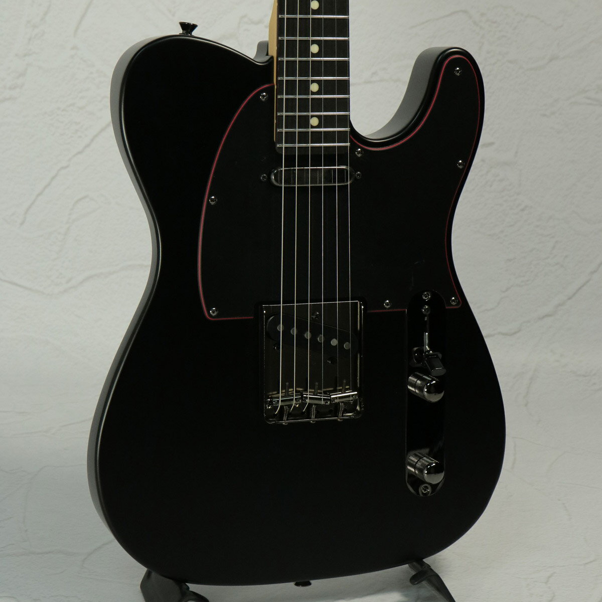 黒と赤を基調とした『Noir』シリーズが限定生産にて復活！Made in Japan Limited Hybrid II Telecaster, Noirは、フランス語で黒を表す”Noir”をモデル名に採用した、黒と赤を基調とした力強いルックスの製品です。目を引くレッドのセンターレイヤーを纏った3-Plyブラックピックガードを搭載しており、ヘッドのレッドメタルロゴと相まって独特な雰囲気を醸し出します。金属パーツやプラスチックパーツは全てブラックで統一しており、ナットもSynthetic Boneを搭載。よりヘビーな見た目に仕上げています。ベースとなっている、Hybrid II Telecasterは、定評あるアルダーボディにHybrid II Custom Voiced Single Coilピックアップを装備し、ヴィンテージスタイルのスランテッドブラスサドル仕様のブリッジを搭載。ヴィンテージロッキングチューナー、サテンフィニッシュのネック、Modern “C”シェイプに9.5インチラジアスの指板とナロートールフレットがスムーズなプレイヤビリティを提供します。※本製品は2025年の限定生産品です。■付属品：ソフトケース、正規2年保証■シリアルナンバー:JD25023663■重量：3.47kg 製品仕様 Body MaterialAlderBody FinishSatin UrethaneNeckMaple, Modern “C”Neck FinishSatin UrethaneFingerboardRosewood, 9.5” &#40;241 mm&#41;Frets22, Narrow TallPosition InlaysWhite Dot &#40;Rosewood&#41;Nut &#40;Material/Width&#41;Synthetic Bone, 1.650” &#40;42 mm&#41;Tuning MachinesVintage-Style LockingScale Length25.5” &#40;64.77 cm&#41;Bridge3-Saddle Vintage-Style Strings-Through-Body Tele with Slanted Brass Barrel SaddlesPickguard3-Ply Black/Red/BlackPickupsHybrid II Custom Voiced Single Coil Telecaster &#40;Bridge&#41;, Hybrid II Custom Voiced Single Coil Telecaster &#40;Neck&#41;Pickup Switching3-Position BladeControlsMaster Volume, Master ToneControl KnobsKnurled Flat-TopHardware FinishBlack NickelStringsNickel Plated Steel &#40;.009-.042 Gauges&#41;