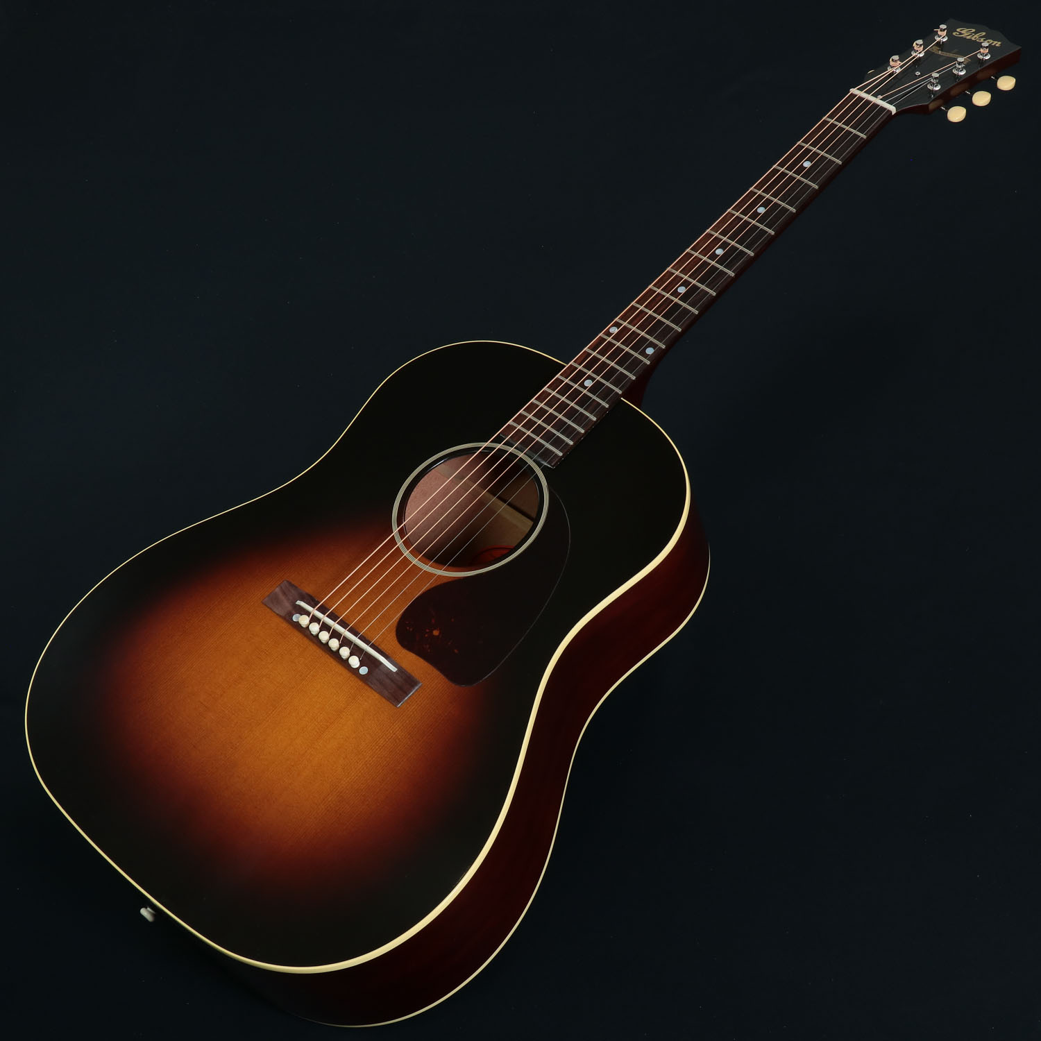 ヒストリック・コレクション 1942 Banner J-45！ 2020年、大幅にラインナップの見直しがされたGibsonアコースティックの中で、注目を浴びた「Custom Shop Collection」。ギブソンが得意としてきたヴィンテージ・リイシューモデルはもちろん、モダンスペックを取り入れたCustomなど多彩なモデルがレギュラーラインナップに加わりました。 本モデルは所謂、初期のJ-45のスペックを踏襲した「Custom Shop Historic Reissue Collection」の1942 J-45 Bannerです。 USA、モンタナ工場製、新品、正規輸入品です。 BODYはもちろんオール単板で、TOPには"アディロンダック・レッド・スプルース"を、SIDE/BACKにはマホガニーを採用。 このTOP板は”Thermally Aged”加工が施されており、Vintageサウンドを再現させるのに一役かっています。この新たな技術によって「木材の経年変化時の特徴、木部内部の油分が抜ける状態、材自体が高質化する状態を再現」しています。 TOPブレーシングは、お馴染みのハンド・スキャロップド・Xブレーシングですが、ブレーシング材にもレッドスプルースを使用し、にかわ接着を採用しています。 また、ヘッドはプリ・ウォー・スクリプトロゴと"ONLY A GIBSON IS GOOD ENOUGH"のバナーヘッド。これは1942-46年頃までの仕様です。 ペグは3連クルーソンタイプを採用し、Groverの重みのあるペグを採用している近年のJ-45スタンダードよりも軽やかにラウドに鳴ってくれます。 ブリッジはレクタンギュラーで、1949年ごろからベリーブリッジになる以前のOld仕様、サドルはロングサドル、ブリッジピンには牛骨を使用しております。 ジャンボフレットが打たれたローズウッド指板を貼ったマホガニーNeckはVintageライクながっしりとしたV-Shapeです。 フレット数は1955年頃から20フレットに変わる以前の”19フレット”仕様。 さらに特筆すべきは、通常の半分の薄さを実現したシン・ラッカーフィニッシュで、さらにV.O.S.（Vintage Original Spec）仕様。 通常のグロスフィニッシュに比べるとサウンドもより大きくなり、また触り心地もヴィンテージライクなフィーリングです。 ルックス、サウンド、フィーリング全てにおいてヴィンテージライクな仕上がりで、「これぞギブソン」と思わせてくれる1本です。 ※V.O.S（ヴィンテージ・オリジナル・スペック）シリーズは艶を抑え、サウンドの向上、ヴィンテージ感を出す為に表面の塗装を特殊にしているもので、新品商品でも使用感のような擦れのようなものが見られますが、不良ではございません。よって、ポリッシュなどの使用はお控え下さいませ。 ※ラッカー仕上げ特有の塗膜の凹凸や、ヘアラインやバズマークといった研磨痕が生じている場合がございます。いずれもハンドメイドが故のもので、製品・演奏上の問題はございません。予めご了承くださいますようお願い申し上げます。 ■付属品：ハードケース、認定証、ストラップピン、クロス、ピックケース、正規保証 ※ご購入いただいたご本人様に限り、メーカー規定の故障に対して保証が提供されます。保証修理受付の際は「ご購入時の領収書もしくは納品書」をご提示いただきます。 製品仕様 Body Shape J-45 Top Thermally Aged Red spruce Back Mahogany Side Mahogany Bracing Traditional hand-scalloped X-bracing, red spruce braces with hide glue Binding 1-ply top and back Finish Thin Finish Nitrocellulose, VOS Neck Material Mahogany Profile V Scale Length 24.75" / 628.65mm Fingerboard Material Rosewood Fingerboard Radius12" Number Of Frets 19 Frets Legend Wire Nut Material Bone Nut Width 1.72" / 43.81mm Inlays Mother-of-pearl Dots Joint Compound Dovetail Neck-to-body Tuner Plating Nickel Bridge Rectangle, open slot Saddle Material Bone Tuning Machines Strap open back, cream button Pickguard Tear Drop Truss Rod Cover Black Bridge Pins Bone