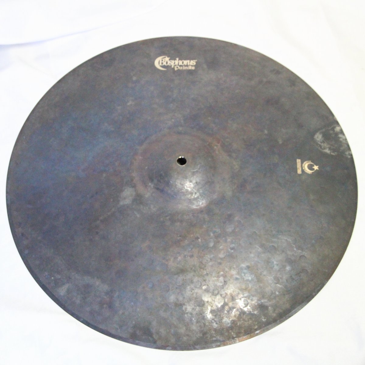 1996年の創業当初よりハンドメイド製造を貫き、他のトルコシンバルメーカーと 一線を画したサウンドで高い人気を誇るボスフォラス。 こちらは2024年2月に発表された新シリーズ、Painite（ペイナイト）のクラッシュシンバルです。 シンバル成型後に3ヶ月間土の中に埋めることで金属を熟成させるという 新しい工法で生まれ、鉱物のペイン石を思わせる独特な漆黒の外観が特徴となっております。 小さめのカップにボスフォラスならではの薄くしなやかに仕上げられたボディとなっており、 サウンドはドライでトラッシーながら小気味良いピッチ感が特徴となっております。 薄めのウェイトならではの横にバシーン！と広がる抜け感が気持ちよく、 幅広いジャンルにマッチするポテンシャルを秘めた1枚となっております！ サイズ：18インチ ※店頭でも展示販売している商品に付き、指紋等が付着している場合がございますが、 サウンド、クオリティには問題ございません、予めご了承くださいませ。