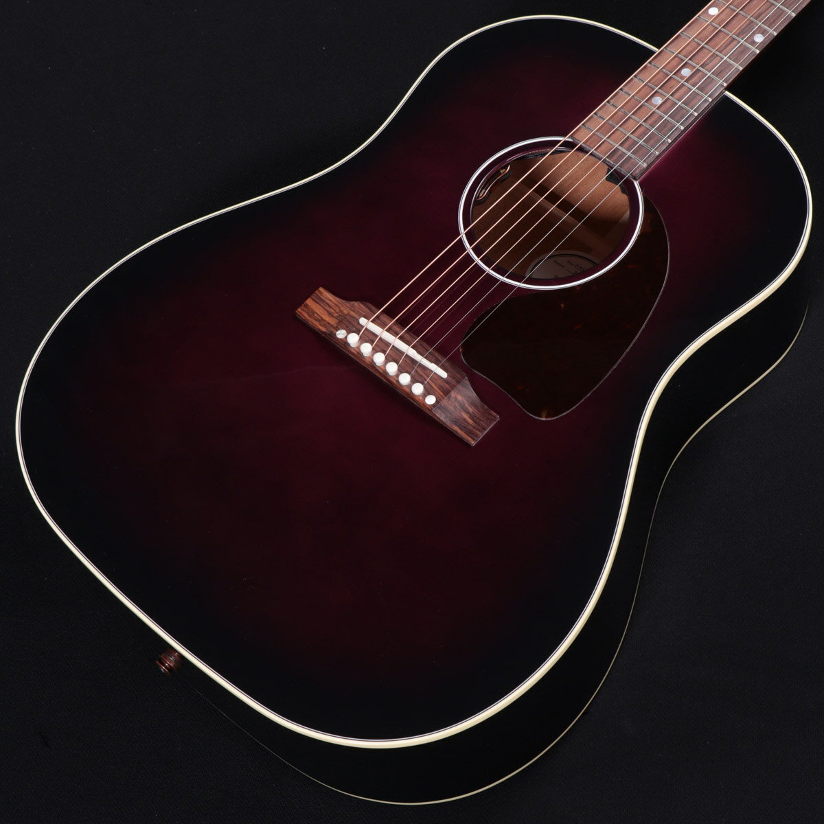 ギブソン アコギの定番モデルJ-45スタンダードの新カラー！ J-35の後継機種として1942年に誕生した、ラウンドショルダー・アコースティックギターの「J-45」。 現在に至るまで多くのミュージシャン・ギタリストに愛され続けてきたモデルで、"The Workhorse"という異名を持ちます。 当時45ドルで発売されていたことでこのネーミングになりました。 オリジナルJ-45は誕生から28年間ラウンドショルダーの代表格として君臨していました。しかし、1970年に変革期を迎え、スクエアショルダー＆ロングスケールへと変貌を遂げます。1982年に生産完了となりますが、1984年に待望の「ラウンドショルダー＆24-3/4インチスケール」として復活します。2009年にニューモデルとして「J-45 Standard」が誕生し、その後ピックアップやオイル塗布された指板エッジの処理等の細かなアップデートがされ、現在に至ります。 USA、モンタナ工場製、新品、正規輸入品です。 本モデルはその長年愛され続ける定番J-45スタンダードを妖艶な雰囲気を感じさせるモダンなパープルバーストに仕上げたNEWモデル！ BODYはオール単板で、TOPにシトカ・スプルースを、SIDE/BACKにマホガニーを採用。フラットなティアドロップ・ピックガード、3Plyバインディングの1リングロゼッタを採用。 マホガニーNECKは演奏性の高いスリムテーパープロファイル、ナット幅1.725インチで多くのギタリストにフィットしやすいシェイプです。また、指板のエッジ部が丸みを帯びている点も特徴的で、スムーズなフィンガリングを可能にしてくれます。 にかわ接着のダブテイルNeckジョイント、ニトロセルロース・ラッカーフィニッシュ（グロス）はお馴染み。 ピックアップにはL.R. Baggs Element VTCを搭載しており、サウンドホールエッジ脇でVolume/Tone コントロールが可能です。 ハウリングに強く、さらにバランスが取れたサウンドを実現しており、ライブで重宝することでしょう！ スキャロップドXブレーシングによるラウドなBODY鳴りも健在で、腰のある低・中音域はJ-45ならではです。 ステージ映えすること間違いなしのモダンカラーを採用したNEWモデル、要チェックです。 ※ラッカー仕上げ特有の塗膜の凹凸や、ヘアラインやバズマークといった研磨痕が生じている場合がございます。いずれもハンドメイドが故のもので、製品・演奏上の問題はございません。予めご了承くださいますようお願い申し上げます。 主な仕様 Body : Mahogany Top : Sitka spruce Finish : Nitrocellulose Neck Material : Mahogany Neck Profile : Slim Taper Scale Length : 24.75'' Fingerboard Material : Rosewood Fingerboard Radius : 12'' Number of Frets : 20 Frets : Standard Nut Material : Tusq Nut Width : 1.725'' Inlays : Mother-of-pearl dots Hardware Finish : Nickel Bridge : Traditional belly up, Rosewood Bridge Pin : Material Tusq Tuning Machines : Grover Rotomatics w/ Kidney Buttons Pickguard : Tear Drop Pickup : LR Baggs VTC Controls : 1 Volume, 1 Tone ■ シリアル : 22385082 ■ JAN : 4570156013934 ■ 付属品：ハードケース、ストラップピン、クロス、ピックケース、正規保証 ※ご購入いただいたご本人様に限り、メーカー規定の故障に対して保証が提供されます。保証修理受付の際は「ご購入時の領収書もしくは納品書」をご提示いただきます。 複数のサイトに掲載しておりますため、他のサイトにて既にご販売済みである場合もございます。 売却に伴う商品情報の削除は迅速を心掛けておりますが、ご注文後に万一売り切れとなっておりました際は誠に申し訳ございませんがご容赦くださいませ。
