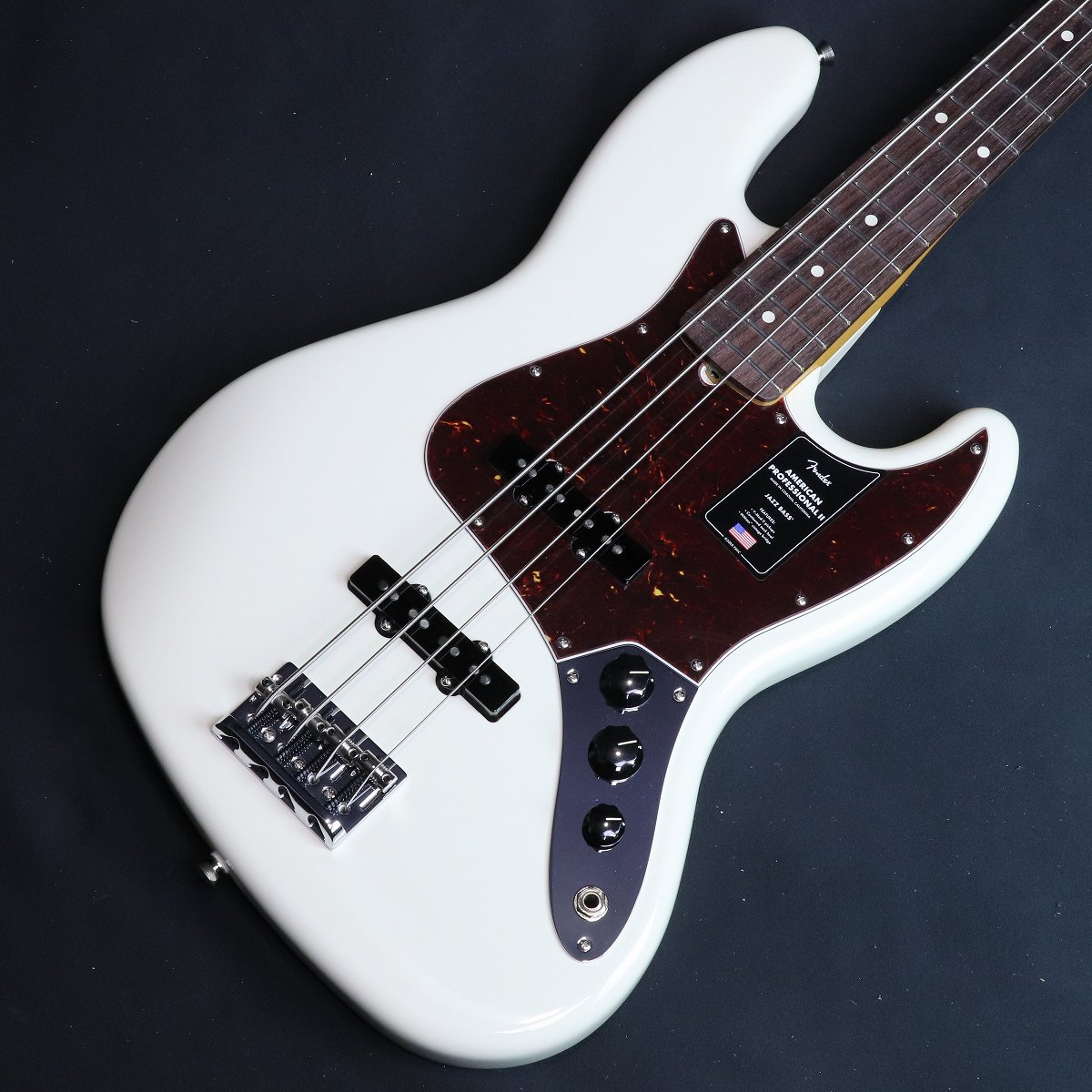 プロアマ問わず大人気のUSA製フェンダー、アメプロがパワーアップして登場！American Professional II Jazz Bass、60年以上に渡る革新、インスピレーション、進化を経て、現代のプレイヤーの要求に応えます。人気のSlim Cシェイプネックは、丁寧にエッジがロールオフされ、至高の演奏体験を約束する"Super-Natural"サテン仕上げが施されています。また新たに設計されたネックヒールを採用し、快適なフィーリングとハイポジションへの容易なアクセスを実現しました。新しいV-Mod II Jazz BassSingle-Coilピックアップは、これまで以上に繊細なトーンを奏で、Jazz Bassならではのパンチとクラリティを提供します。American Professional II Jazz Bassの手に馴染む感覚とサウンドの多様性は、手に取り、耳にした瞬間、すぐにお分かりいただけることでしょう。プロの楽器の新たなスタンダードとなるような幅広い改良が、American Professional IIシリーズには詰め込まれています。主な仕様Body Material AlderBody Finish Gloss UrethaneControl Vintage Style Black Plastic Jazz BassFingerboard RosewoodHardware Finish Nickel/ChromeNeck Finish “Super-Natural” Satin Urethane Finish on Back of Neck with Gloss Urethane Headstock FacePickguard 4-Ply TortoiseshellPosition Inlays White DotNeck MapleNeck Shape Slim "C"Scale 34" (864 mm)Fingerboard Radius 9.5" (241 mm)Frets 20Frets Size Narrow TallNut BoneNut Width 1.5" (38.1 mm)Bridge Pickup V-Mod II Single-Coil Jazz BassMiddle Pickup V-Mod II Single-Coil Jazz BassNeck Pickups Controls Volume 1. (Middle Pickup), Volume 2. (Bridge Pickup), Master TonePickup Switching NoneBridge 4-Saddle HiMass Vintage (String-Through-Body or Top-Load)Tuning Machines Fender Lightweight Vintage-Style Keys with Tapered ShaftsStrings Fender USA 7250M Nickel Plated Steel (.045-.105 Gauges), PN 0737250406Case/Gig Bag Deluxe Molded Case (Included)■付属品：レンチ、ハードケース、メーカー正規保証書 ■保証:2年 ■JANコード:0885978579976 ■シリアルナンバー:US25061859 ■重量:3.99kg ※こちらの商品は店頭展示品の為、画像に写りにくい磨き傷などがある場合がございます。