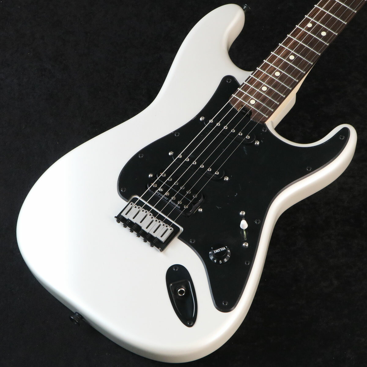 人気のジェイク・E・リーモデルがPro-Modシリーズより登場！ギターの名手であるジェイク・E・リーは、Ozzy Osbourneのリードギタリストとして彼の伝説的なギグへとたどり着く前に、1980年代に、RattそしてRough Cuttでその情熱を燃やしました。彼の絶賛されたキャリアはRed DragonCartelで今日も続いており、Charvelはそれらの彼の音楽遍歴におけるあらゆる場面で愛用されてきました。CharvelはJake E Lee USA Signatureギターによって、そのダイナミックなギタリストを称え、本モデルの仕様は、偉大なギタリストが1975年に新品で購入して以来、ずっと演奏してきた特徴的なホワイトの「シャーベル化（Charvel-ized）」されたギターに基づいています。これまで最も人気の高いモデルの1つであるこの25.5インチスケールのシグネチャーSo-Calモデルは、アルダーボディ、グラファイト補強され、手作業によるサテン仕上を背面に施したボルトオン式メイプルネック、12〜16インチのコンパウンドラジアス仕様ローズウッド指板に、21本のジャンボフレットとホワイトのドットインレイを備えています。また、ヒールマウントされたトラスロッドアジャストメントホイールでスムーズで簡単なネック調整が可能です。リアにパワフルな低音と煌めく高音をもたらすSeymour Duncan JB SH-4 ハムバッカーピックアップ、センターとフロントにはパンチと暖かみを与え、より深淵なボトムエンドをもたらすDiMarzio SDS-1シングルコイルピックアップを搭載しました。他にも、5ウェイブレードスイッチ、Stratスタイルのボリュームコントロールノブ1基、ブラックのプレート付ハードテールブリッジ、パールボタン付きCharvel製チューニングマシンを採用し、高い汎用性を誇ります。スポットライトを独り占めにするJake E Lee SignaturePro-Mod So-Cal Style 1 HSS HT RWは、ブラックのピックガードとハードウェア、フェンダーライセンスのストラットヘッドで、虹色に輝くPearl Whiteカラーで仕上げられています。■ 重量：3.35kg■ JAN：0885978622627■シリアル：MC253460 製品仕様 ModelJake E Lee Signature Pro-Mod So-Cal Style 1 HSS HT RW Rosewood Fingerboard Body_MaterialAlder Body_FinishGloss NeckMaple, Speed Neck with Rolled Fingerboard Edges Neck_FinishHand-Rubbed Satin Urethane FingerboardRosewood, 12”-16” Compound Radius (304.8 mm to 406.4 mm) Frets21, Jumbo Position_InlaysWhite Dot (Rosewood) Nut_Material/WidthPlastic, 1.6875” (42.86 mm) Tuning_MachinesCharvel-Branded with Pearl Buttons Scale_Length25.5” (648 mm) BridgeHardtail Bridge with Black Base Plate Pickguard1-Ply Black PickupsSeymour Duncan JB SH-4 (Bridge), DiMarzio SDS-1 DP111 (Middle), DiMarzio SDS-1 DP111 (Neck) Pickup_Switching5-Position Blade|Position 1|Bridge Pickup|Position 2|Bridge Outer Coil and Middle Pickup|Position 3|Middle Pickup|Position 4|Middle and Neck Pickup|Position 5|Neck Pickup ControlsVolume Control_KnobsBlack Strat-Style Skirt Hardware_FinishBlack StringsNickel Plated Steel (.009-.042 Gauges) Case/Gig_BagSoftcase ※こちらの商品は現物1点限りを、店頭展示を含め複数のモールに同時掲載しております。 売却に伴う商品情報の削除は迅速を心掛けておりますが、必ずしもリアルタイムではございません。 ご注文後に万一売り切れとなっておりました際は、誠に申し訳ございませんがご容赦くださいませ。