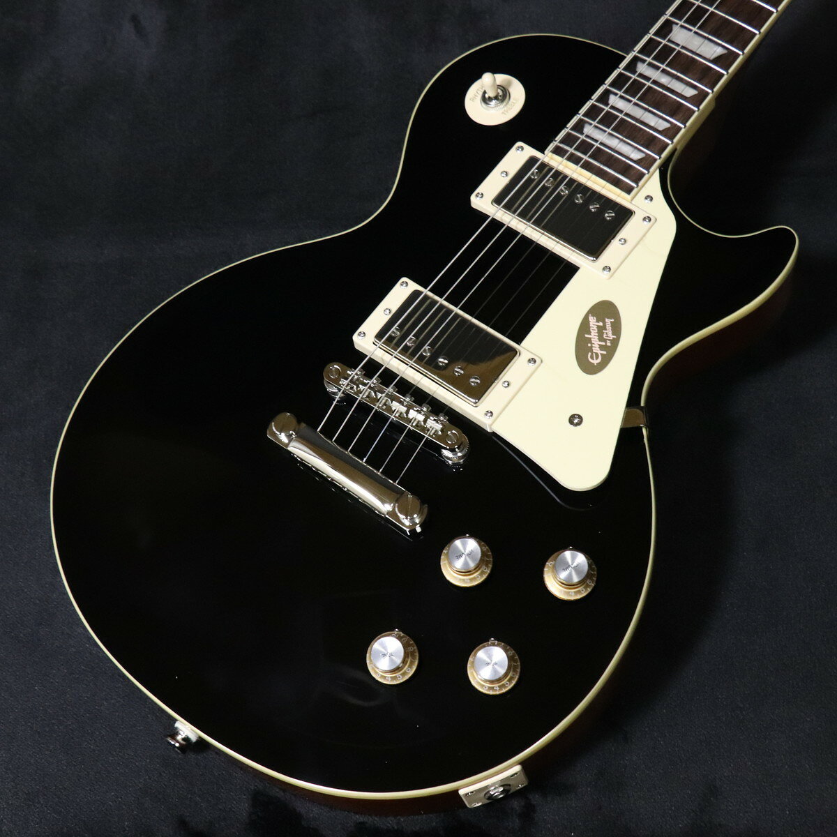 Epiphoneレスポール・スタンダードがアップデート!1958 1960年製のGibson Les Paul Standardほど、伝説的な評価を誇るギターは多くありません。その美しさ、滑らかな演奏性、そして卓越したトーンにより、世界中のコンサート・ステージや数多くのヒット・レコーディングで使用されてきた、地球上でもっとも愛されているヴィンテージ・ギターのひとつです。エピフォンは今回、そうした伝説的モデルへのオマージュとして、Inspired by GibsonシリーズよりLes Paul Standard 60sをアップデートしてリリースします。本モデルは、1960年代初期のLes Paul Standardが持つフィーリングとサウンドを忠実に再現した1本です。Les Paul Standard 60sは、1960年代初期のLes Paulが持つルックス、フィーリング、そしてサウンドを再現しています。マホガニー・ボディにメイプル・キャップを組み合わせ、Les Paulならではの豊かなトーンを実現しています。マホガニー・ネックにはローズウッド指板を採用し、パーロイド・トラペゾイド・インレイ、ミディアム・ジャンボ・フレット、そして素早い演奏性を実現するスリムテーパー60s Cプロファイルを備えています。カラマズー・ヘッドストックには、エピフォンVintage DeluxeチューナーとGraph Techナットを搭載し、安定したチューニング性能を実現しています。ピックアップには、高い評価を受けているエピフォンProBuckerピックアップをバランスよく搭載し、ネック・ポジションにProBucker 2、ブリッジ・ポジションにやや出力の高いProBucker 3を配置しています。さらに、高品質なCTSポテンショメーターを採用しています。Les Paul Standard 60sは、手の届きやすい価格帯でありながら、本格的なLes Paulの演奏体験を楽しめるモデルです。プレミアム・ギグバッグが付属します。 ■ 重量:3.84kg ■ JAN:4570156013248 ■ 付属品:ギグバッグ、正規保証※ご購入いただいたご本人様に限り、メーカー規定の故障に対して保証が提供されます。保証修理受付の際は「ご購入時の領収書もしくは納品書」をご提示いただきます。 製品仕様 ShapeLes Paul Body MaterialMahogany TopMaple BindingSingle Ply, Top and Fretboard NeckMahogany Neck ProfileSlimTaper 60s C Nut width1.69”/43mm FingerboardRosewood Scale length24.75”/628.65mm Number of frets22 NutGraphTech InlayPearloid Trapezoid BridgeLockTone Tune-O-Matic TailpieceLockTone Stop Bar TunersGrover Rotomatic with Kidney Button Control KnobsGold Top Hat with Nickel Reflector and Dial Pointer PlatingNickel Neck pickupProBucker 2 Bridge pickupProBucker 3 Controls2 Volume, 2 Tone; CTS Potentiometers CasePremium Gig Bag ※こちらの商品は現物1点限りを、店頭展示を含め複数のモールに同時掲載しております。 売却に伴う商品情報の削除は迅速を心掛けておりますが、必ずしもリアルタイムではございません。 ご注文後に万一売り切れとなっておりました際は、誠に申し訳ございませんがご容赦くださいませ。