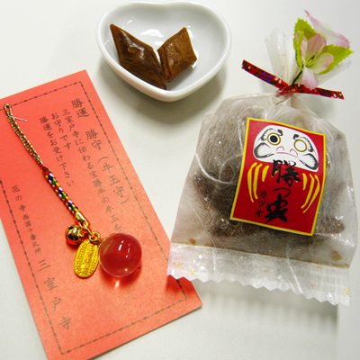 名称 飴菓子 原材料 黒砂糖、中双糖、水飴、桂皮末、香料、着色料（赤102・赤106・黄4・青1）内容量50g（飴） 賞味期限365日保存方法高温多湿を避け、開封後なるべくお早くお召し上がり下さい。 製造者 株式会社岩井製菓 〒611-0013 京都府宇治市莵道丸山203-3 TEL.0774-21-4023 注意事項 本商品は、複数個ご購入の場合でも割引は適用されません。 ■ レビュー書き込みで次回あめプレゼント ご注文選択項目の『レビューを』の欄で『書く』をご選択頂くと、次回の注文時、飴（非売品）をプレゼントいたします。 ※次回の注文商品と同梱いたします。 ※1回の注文につき、プレゼントは1つです。（本件に該当する商品を一度に複数ご注文いただいた場合でもプレゼントは1つとなります。） ※レビューの書き方がわからない方はこちらをご覧ください。勝運をつかむ☆縁起グッズ　勝つ央 お守り付 京の飴工房近くにある「西国十番礼所三室戸寺」。 本堂前に「宝勝牛」が鎮座しております。 勝運にご利益のある宝勝牛に因んだ「お守りとかつお飴（ニッキ黒飴）」をセットにした必勝祈願飴です。 大切な人の願いを叶える手助けをしませんか？ 「勝つ央」・・・かつお飴（ニッキ黒飴） 黒飴のまわりにニッキ粉（桂皮末）をまぶし、創作したオリジナル飴です。絶妙の味わいをお楽しみ下さい。 勝運 勝守（牛玉守） 三室戸寺に伝わる宝勝牛の牛玉を形どったお守りです。試験や試合など勝負の勝運をお受け下さい。