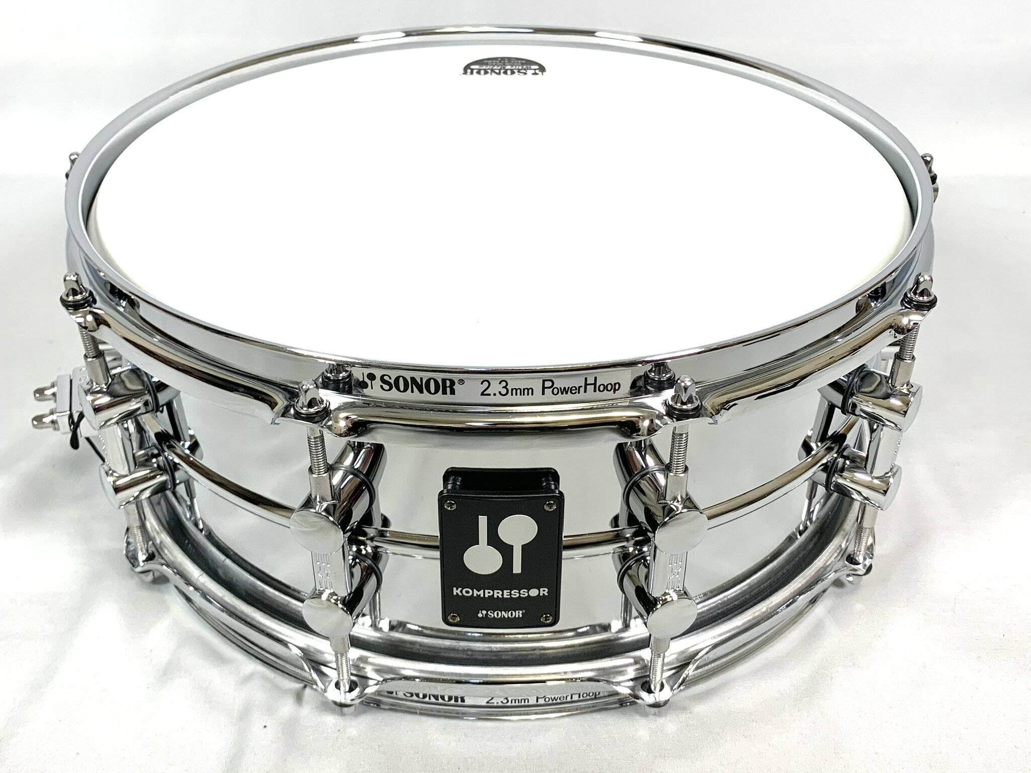 SONOR KS-14575SDS 特徴 SONOR KOMPRESSOR Series 新しいコンプレッサーシリーズのスネアドラムは、空気をピュアな音エネルギーに変え、一打目から息を呑むようなサウンドを奏でます。 繊細なレスポンス、パワフルで特徴的なSONORサウンドはもちろん、幅広い素材とサイズバリエーションにより、様々な音楽スタイルに対応するポテンシャルを実現。 まさに「真の主力製品」と呼ぶにふさわしい仕上がりとなりました。 シェル径をわずかに小さく成形する OSM（Optimum Shell Measurements）機構 を採用したことによって、ヘッドからシェルへの振動伝達をよりナチュラルに。さらに過酷な状況下でもチューニングを安定させるため、すべてのスネアドラムでTuneSafeラグを装備しております。 SONOR KS-14575SDS 仕様 ■SONOR チューンセーフ内蔵ダブルラグ（KS1408SDAのみシングルラグ） ■OSM機構（Optimum Shell Measurement） ■SONOR スタンダード・スローオフ ■スティール20本線 スネアワイヤー ■USA製REMOヘッド ■サイズ：直径14×深さ5.75インチ ■シェル材：1mm厚 スティールシェル ■フィニッシュ：クロームフィニッシュ ■フープ：2.3mm厚 10テンション スティールパワーフープ ■付属品:ドラムキー ※スネアドラムは店頭で試奏もしております。そのためヘッドには試奏跡が付く場合がありますので予めご了承ください。 ヘッドにやや使用感が強くなった場合は同等のヘッド張替、または1枚サービスを行っております。 ご不明なところなどございましたらお気軽にジュージヤ三条本店stage(TEL:075-254-3700)ショップまでお問い合わせください。 ★掲載の商品は店頭や他のECサイトでも並行して販売しております。在庫情報の更新には最大限の努力をしておりますが、ご注文が完了しましても売り切れでご用意できない場合がございます。 　また、お取り寄せ商品の場合、生産完了などの理由でご用意できない場合がございます。 　その際はご注文をキャンセルさせていただきますので、予めご了承くださいませ。 ★お届け先が北海道や沖縄、その他離島の場合、「送料無料」と表記の商品であっても別途中継料や送料を頂戴いたします。その際は改めてご連絡を差し上げますのでご了承ください。　