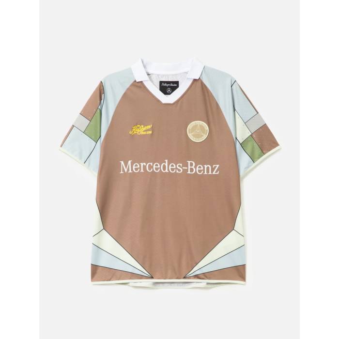 ブランド名Kidsuper商品名Kidsuper X Mercedes Benz Soccer JerseyカラーNULL■ はじめに この度は数ある商品の中から、唯一無二の存在感を放つ「Kidsuper X Mercedes Benz Soccer Jersey」にご興味をお持ちいただき、誠にありがとうございます。 ファッションとモータースポーツ、異なるフィールドで輝きを放つ二つのブランドが融合した、特別なサッカージャージをご紹介いたします。こちらは単なるスポーツウェアに留まらない、アートピースのような魅力とストリートカルチャーのエッセンスを凝縮した逸品です。高感度なデザインと快適な着心地が両立した、今シーズン注目のコラボレーションアイテムをぜひご覧ください。 ■ 商品説明・スペック 「Kidsuper X Mercedes Benz Soccer Jersey」は、斬新なデザインと機能性を兼ね備えた、特別なサッカージャージです。 ・素材の選定 現代のスポーツウェアに求められる高い機能性を追求し、速乾性、通気性、軽量性に優れた高品質なポリエステル素材を採用しております。汗を素早く吸収・発散し、常に※画像はイメージです