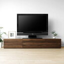 Walnut Wood Furniture／ウォールナット材のテレビボード 180cm # MEMO商品説明 ウォールナット天然木を使用した洗練されたデザインのテレビボード（幅180cm）。 引き出し・扉の前板にスリットの入ったモダンなデザインのテレビ台に仕上がっており、高級感、素材感が際立つ収納家具です。 180cmタイプは右側がAV機器収納スペース、左側がDVD・BD収納に適した大引き出しになっていて収納力も抜群です。高さ30cmのローボードなのでお部屋に圧迫感なく設置ができます。 # DETAIL商品詳細 オシャレな格子デザイン前板にスリットが入ったオシャレなデザインのテレビ台です。扉は彫り込み取手なのですっきりとした外観で使い勝手も良いです。 デッキスペース、可動棚扉を開けるとデッキを4台設置できるスペースとハードディスクやゲーム機などを縦置きできるサイドスペースがあります。棚板は可動棚なので3段階の昇降調節が可能です。 スライドレール引き出し、DVD収納引き出しはフルオープン仕様のスライドレール付きで開閉もスムーズに。DVD・BDの収納に適した大引き出しです。 天板、配線孔天板の後部には配線用のコードホールが設けてあり、ここにテレビやデッキのコードを通していただけます。 格子扉格子扉は閉めたままデッキのリモコン操作ができるように裏にガラスがはめ込んであり、埃の侵入を防ぎます（デッキの大きさによってはリモコンの赤外線が通らない場合があります）。 ソフトダウンステー扉はフラップ（前に倒れる）扉を採用しており、ソフトダウンステー金具を使用しています。 小引き出し、収納ボックス引き出し内部には説明書などの収納に便利な小箱が付属しますので合わせてお使い下さい。 側板、巾木除けテレビボードの側面後側には巾木をよけるために12ミリ×80ミリのサクリ加工が施してあり、ここからコードを通すこともできます。 # PHOTOS商品画像 # COORDINATEコーディネート 同じシリーズのテレビボードで幅150cmと幅180cmのものを2本組み合わせたレイアウト写真です。組み合せることで幅330cmのワイドサイズのテレビボードになります。 # RECOMMEND関連商品 REAGATO TVボード 240cm REAGATO TVボード 150cm REAGATO TVボード 210cm REAGATO TVボード 210cm ホワイトオーク # INFOMATION商品情報 サイズ幅1802×奥行471×高さ300mm 素材前板：ウォールナット無垢材/外装・内装：ウォールナット突板・化粧合板 塗装ウレタン塗装（F☆☆☆☆） 備考天板耐荷重：80kg/完成品/背面化粧無し 生産国日本 送料北海道・沖縄・一部地域・離島は別途料金がかかります 配送こちらの商品は開梱設置配達サービス（ヤマトホームコンビニエンス）での配送となります。 ※天然木を使用しているため商品表面に節や白太、赤身などでる場合がございますが予めご了承ください。 同じシリーズの商品はコチラ