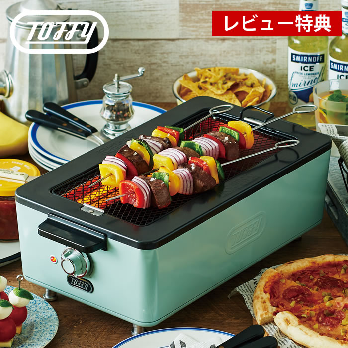 商品名 Toffy スモークレス焼肉ロースター K-SY1 商品詳細 サイズ 本体：約W437×H155×D235mm 焼き網：約W315×D150mm※取っ手含まず 平面プレート：約W333×H40×D113mm 電源コード長：約1.3m 重量 約3050g 電源 AC100V 50/60Hz 定格消費電力 1000W 付属品 焼き網、平面プレート、マグネットプラグ付電源コード、ユーザーズガイド(保証書含む) 保証期間 1年 生産国 中国 備考 ※水洗い不可（本体） ※食洗器、乾燥機不可（本体、焼き網、平面プレート、水受けトレイ含むすべて） ※ご使用開始の前に本体に同梱されているユーザーズガイドをお読みいただき、注意事項等をご確認の上で正しくお使いください。 検索キーワード Toffy スモークレス焼肉ロースター K-SY1-PA 煙の出ない 焼肉 プレート 無煙 ロースター 焼き鳥 網焼き バーベキュー 遠赤外線 宅飲み 室内 キッチン 家電 卓上 コンパクト 調理 ペールアクア おしゃれ トフィー ラドンナ プレゼント フィッシュロースター toffy ladonna 焼き肉プレート コンロ 電気 ラッピング ラッピングOK →詳細はこちらToffy スモークレス焼肉ロースター K-SY1 驚くほどの低煙性能！スモークレス焼肉ロースター お家で焼き肉をする時などにどうしても気になるのが「煙」。部屋が汚れたり、ニオイが付いたりで困りますよね。このロースターは熱源となるヒーターを側面に配置する「サイドヒーティング方式」を採用することによって、今までにない低煙性能を実現。食材から滴る油分がヒーターに触れにくい構造で煙を大幅にカットします。 焼き網と平面プレートが付属するので焼くものや調理方によって使い分けられ、網とプレートはふっ素加工で食材がこびりつきにくい仕様。無段階で調節できる温度調節ダイヤルや、取り外しが容易な引き出し式の水受けトレイなど、使い勝手も抜群。どこかレトロなデザインにペールカラーがおしゃれでインテリアにも馴染みます。 ※水受けトレイからはねた油分がヒーターに触れると煙が発生します。油脂の多い食材の場合、網の中心で焼いていただくことで煙を抑えることができます。 ※平面プレートは食材の油分がプレートに溜まるので煙が発生します。煙を抑えて調理したい場合は焼き網をご使用ください。 関連商品 スモークレス焼肉ロースターK-SY1 スモークレス焼肉ロースター専用焼き網 2枚入り スモークレス焼肉ロースター専用平面プレート →シリーズ一覧を見る