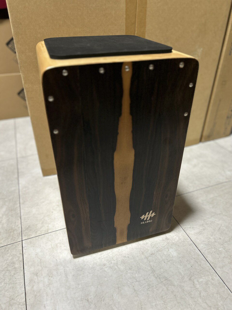 商品情報説明HLURUのカホンは、美しい天然木製の打楽器で、独特のストライプ模様が特徴的です。伝統的なペルー発祥の打楽器を現代的にアレンジし、プロフェッショナルな演奏から気軽な音楽セッションまで幅広く活用できます。側面には装飾的なデザインが施されたサウンドホールがあり、豊かな共鳴と深い低音を生み出します。木目の美しさと職人技が融合した本体は、楽器としての機能性だけでなく、インテリアとしても魅力的です。座って演奏しやすい高さと、持ち運びに便利なサイズ設計で、様々な演奏シーンに対応。スネアワイヤーを内蔵し、クリアで力強い音色を実現しています。パーカッションアンサンブルやアコースティックセッションで、リズムの要となる存在感のある楽器です。サイズ約29.2 x 49.5 x 30.5 cm付属品ケース、パッドHLURU WT49CN-Z カホン ドラム ドラマー パーカッション パーカッショニスト 打楽器 drum drummer percussion cajon 木材 wood アコースティック acoustic 音楽 楽器 機材 music 木目がかっこいい1品！ 1