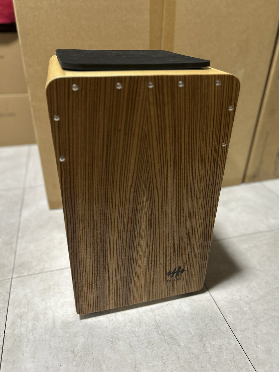 商品情報説明HLURUのカホンは、美しい天然木製の打楽器で、独特のストライプ模様が特徴的です。伝統的なペルー発祥の打楽器を現代的にアレンジし、プロフェッショナルな演奏から気軽な音楽セッションまで幅広く活用できます。側面には装飾的なデザインが施されたサウンドホールがあり、豊かな共鳴と深い低音を生み出します。木目の美しさと職人技が融合した本体は、楽器としての機能性だけでなく、インテリアとしても魅力的です。座って演奏しやすい高さと、持ち運びに便利なサイズ設計で、様々な演奏シーンに対応。スネアワイヤーを内蔵し、クリアで力強い音色を実現しています。パーカッションアンサンブルやアコースティックセッションで、リズムの要となる存在感のある楽器です。サイズ約29 x 49.2 x 30 cm付属品ケース、パッドHLURU WT49CN-ZW カホン ドラム ドラマー パーカッション パーカッショニスト 打楽器 drum drummer percussion cajon 木材 wood アコースティック acoustic 音楽 楽器 機材 music 木目がかっこいい1品！ 1