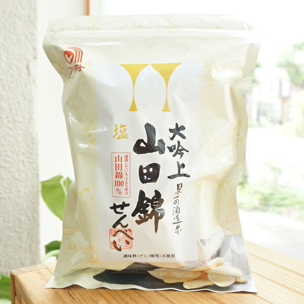 ■日本一の酒造米である「山田錦」の原料にこだわり、やさしい味のお煎餅に仕上げました。 ■「山田錦」は至高の日本酒を生み出す最高の原料として、酒造メーカーから高く評価されており、中でも大吟醸酒・吟醸酒を造るには、これしかないと言われているほどです。そんな最高のお米でおせんべいを焼き上げました。 ■お酒の味はしませんが、お米本来の味を大切にしつつ、後を引く美味しさのシンプルなサラダ味に仕上げました。 ■「加工でん粉」や「でん粉」を使用せず、お米自身の膨張力だけでサクッとした食感を実現しています 【原料名】うるち米（国産山田錦）、米油、塩、昆布粉末、鰹節粉 【内容量】22枚(約88g) 合名会社アリモト せんべいとおかきの違いは使用するお米の種類で、せんべいには粘り気の少ないうるち米、おかきは粘り気のあるもち米が使われる。 せんべいは平べったい形が多く、硬めで膨らみにくいが、おかきは火を通したときに膨らみやすく、せんべいより柔らかい。 せんべいとおかきの歴史は古く、どちらも庶民のお菓子として長く親しまれてきました。 焼きせんべい専門のメーカーであるアリモトの創業は昭和27年(1952年)。 火災や阪神大震災を乗り越え成長してきた。 自然食品店でよく販売されているアリモトの代表的なせんべいである玄米100％の「玄米このは」は1961年から製造されているロングセラー商品だ。 一般の玄米せんべいと言われるものの多くが玄米を白米に精米し、その白米を製粉してから糠を足すのに対し、アリモトは玄米から製粉する。 これは特殊な製粉機が必要で、玄米せんべいのラインナップが多いアリモトならではの強みだ。 原料にもこだわりがある。 国内産原料、天日製塩法による原塩のみを使用して約1年以上熟成して作られた醤油を使い、アリモトの全ての玄米せんべいには有機JAS認定のお米を使用。 現場には「山田錦せんべい」の原料が順番待ちをしていた。 「せんべいの生地製造から焼きまで」を自社で一貫して行う。 生地を仕入れて焼きだけを行なうおせんべい屋さんが多いなか、アリモトでは生地作りからこだわってせんべいを作っている。 自社で製粉した玄米粉と水を混ぜ、団子を作り、薄く延してから乾燥してゆく。 何％の乾燥具合なら次はこの工程と何度か機械を渡り歩いて最終の焼き工程。 「ここが一番難しくて、私は出来ません。」と代表の有本さん。 この焼きの工程のベルトコンベア内でも乾燥と焼き(膨らませ)があり、工場長の職人技でガスの調整を行い、アリモトのせんべいが出来上がってくる。