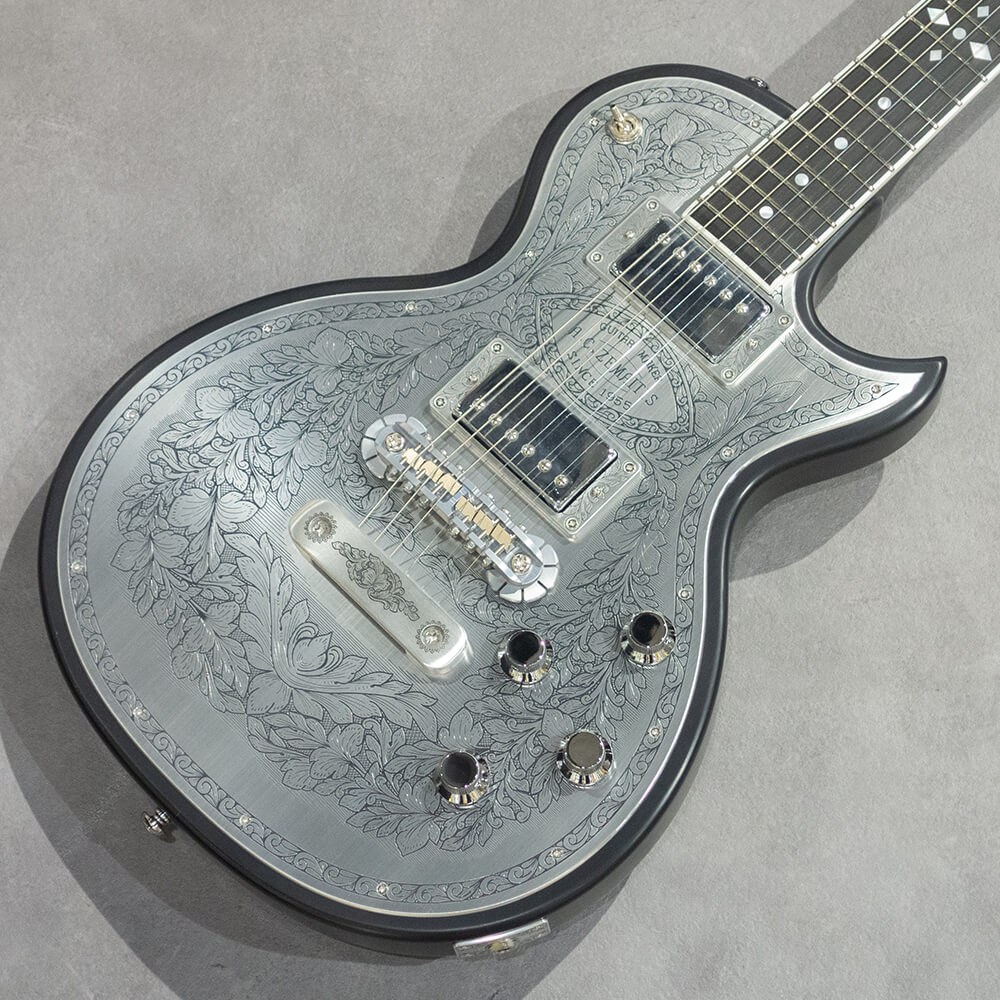 トピックスショッピングクレジット分割48回払いまで金利手数料0%！期間限定 2025年11月30日まで30,000円（税込）以上のお買い物が対象となります。本キャンペーンはクレジットカードでのお支払いは対象外となります。詳しくはお問い合わせください。アイテム説明MFG-AC-22はシングル・カッタウェイのオリジナル・ボディー・スタイルで、ボディーとネックに厳選されたアフリカン・マホガニー、フィンガーボードはエボニーを使用しています。635mmのスケールで、セット・ネック・ジョイント、ミディアム・サイズの22フレット仕様です。ボディー・トップのアルミ合金のプレートにゼマイティスらしいリーフ柄の彫金装飾を全面に加え、伝統を示す「A.C.ZEMAITIS SINCE 1955」の文字が刻まれたデザインなどクラシックなルックスが特徴です。ゼマイティス・オリジナルのアルミ合金を使用したブリッジ&テイルピースを搭載し、ゼマイティス独自のトーンを生み出す要素となっています。同様にアルミ合金を用いたヘッドのダイアモンド・エンブレム、トラスロッド・カバー、テイルピースやピックアップ・リングをはじめ、アウトプット・ジャック・プレート、コントロール&スイッチ・バック・プレートに至るまで彫金を施しています。ピックアップは、メタル・カバード・タイプのDragon Classicハムバッカーを2基搭載、コントロールは定評のあるCTSポットを使用し、各ピックアップ・ヴォリュームと各ピックアップ・トーンのレイアウトです。スイッチクラフト製の3ウェイ・ピックアップ・セレクター・スイッチを備え、トーンのキャパシターはオレンジ・ドロップを使用しています。さらに信頼性の高いゴトー製のチューナーを使用しています。フィニッシュはラッカーを使用し、カラーはブラックです。ハードケースが付属します。Made in JapanスペックBody Top：DuraluminBody Back：Select African MahoganyNeck：Select African MahoganyNeck Joint：Set neckNut Width：43mm (1-11/16")Nut：BoneFingerboard：Bound EbonyScale：635mm (25")Frets：22 MediumNeck Pickup：Dragon Classic NeckBridge Pickup：Dragon Classic BridgeRadius：305mm (12")Controls：2 volume, 2 tone, 3-way toggleTuners：Gotoh? SG301-01-ChromeFinish：LacquerProtection：Hard Shell CaseStrings：Rotosound Nickel Plated Steel(.010 / .013 / .017 / .026 / .036 / .046)Weight：3,94kg納期について売却時は迅速に商品情報の削除を心掛けておりますが、ショッピングページの更新までにタイムラグが生じ、ご注文のタイミングによっては商品のご用意ができない場合がございます。あらかじめご了承くださいますようお願い申し上げます。あす楽対象商品以外、納期のご確認はご注文前に「商品についての問合わせ」よりお問い合わせください。