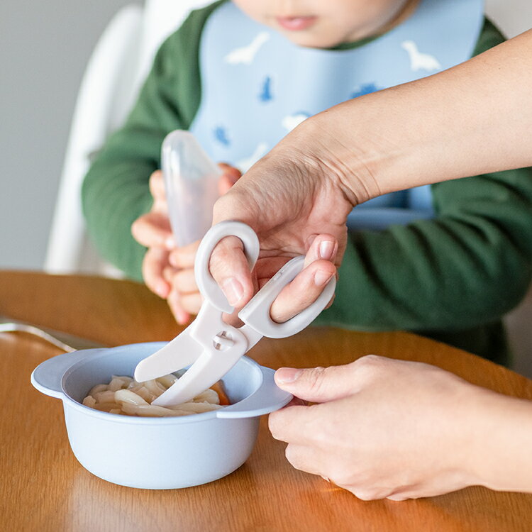 お食事中、お皿の上で、お子様の食べやすいサイズに食べ物を切ることができるフードカッターです。持ち運びに便利なプラスチックのケース付きで、外出先でも大活躍！特に麺類や、やわらかい固形のお野菜などは簡単に切ることができるのでおすすめです。滑りにくく、やわらかい素材の持ちやすいハンドル。切りたい食材が逃げにくいように、カーブした刃先。刃先もまるく、とがっていないので安心です。また、テーブルに置いたときに、刃先がテーブルにつかない形状なので衛生的にご使用いただけます。電子レンジ使用不可×食器洗い乾燥機使用不可×【消毒について】薬液消毒可○煮沸消毒不可×※薬液消毒は、ベビー用の消毒液を使用し、各消毒液の取扱い説明書に基づいてご使用ください。※BPAフリー（環境ホルモンのひとつ、BPAを含みません。）サイズ：ハサミ本体＝約W6.5×D11.5×H1cm／ケース＝約W8×D12×H1.7cm材質：ハサミ本体＝ABS樹脂（耐熱温度80℃）／ハンドル＝熱可塑性エラストマー（耐熱温度60℃）／ケース＝ポリプロピレン（耐熱温度100℃）生産国：中国【取扱い上の注意】 ・必ず保護者の方がご使用ください。 ・最初に使う際は必ず洗ってからご使用ください。 ・火のそばに置かないでください。 ・食器洗い乾燥機は使用しないでください。 ・分解できません。分解しないでください。 ・製品にひび割れ、亀裂、欠けなどが生じたり、著しく変形した場合は、すぐに使用を中止してください。 ・乳幼児の手の届かないところに保管してください。 ・電子レンジで加熱はしないでください。 ・誤った使用方法に起因する損害は一切補償いたしません。 【洗浄・消毒時の注意】 ・雑菌の繁殖を防ぐため、使用後は速やかに洗浄・消毒してください。 ・食材によっては色素が付着する場合がありますので、ご使用後はすぐに洗浄してください。 ・汚れを落とす時は、水で薄めた食器用中性洗剤をご使用ください。 ・たわし・みがき粉などで磨くとキズがつくおそれがありますので、柔らかいスポンジをご使用ください。 ・漂白する時は、台所用塩素系漂白剤をご使用ください。使用する場合は各漂白剤の使い方と使用上の注意をよくお読みください。 ・漂白時間は30分〜40分を限度とし、薄める濃度は各漂白剤の使用方法に従ってください。 　※過度の漂白は製品を早く傷めます。 ・薬液消毒は哺乳びん、乳首専用の消毒液をご使用ください。 ・薬液消毒をご使用の場合、各製品の使用上の注意に従ってご使用ください。 ・アルカリ性洗剤または、オレンジ系洗剤は図柄剥離や変色することがありますので、使用しないでください。 ・熱湯消毒・煮沸消毒は変形することがありますのでしないでください。 ・落としたり、乱暴な扱いにより破損することがあります。