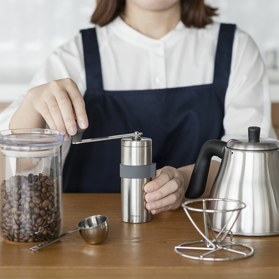 本体は18-8ステンレス製のため錆びにくく衛生的で、刃はセラミック磁器製のため摩耗しにくく豆の風味を損ないません。中のつまみで豆を挽いた際の粗さ(粒度)を調整できます。容器容量：120ml豆容量：17g※豆の焙煎度により異なります。サイズ：W41.2×D30×H1.9cm／重量＝370g 個装箱：52×52×165cm 材質：フタ・容器：18-8ステンレス／本体＝18-8ステンレス・ポリプロピレン・ポリアセタール・ステンレス・鉄(三価クロメート)・PTEF／ハンドル＝ステンレス・ポリプロピレン／刃部＝セラミック磁器／滑り止めグリップ＝シリコーンゴム（中国製） 耐熱について：ポリプロピレン(耐熱温度100℃)、ポリアセタール(耐熱温度100℃)、シリコーンゴム（耐熱温度180℃）生産国：本体：日本／シリコン：中国【取扱い上の注意】・使用の際は、食器用洗剤をスポンジに付けて洗いすすいでください。(容器のみ)・置いて使用する場合は安定した所で使用してください。ぬれた場所や不安定な場所で使うとケガの原因になります。また、持って使用する場合はしっかり握り、手がすべらない状態でご使用ください。・付属の滑り止めグリップは脱着式です。使用の際は本体部分に装着してください。・この製品はコーヒー豆専用です。コーヒー豆以外は使用しないでください。また生豆や極度に湿った豆を使用しますと、破損の原因になります。・使用されるコーヒー豆の大きさは5.5〜7mmのサイズをご使用ください。・コーヒー豆をひいた後は、本体容器に残さず取り出してください。長時間放置されますと、豆から出た油分により凝固する場合があります。・落としたり、ぶつける等の街撃を与えないでください。割れたり、欠ける等の原因になります。割れたり、欠けたりした場合には使用しないでください。・小石等の硬い不純物を挽くと破損の原因になります。・空回しでセラミックが擦れる音がする場合、粗さ(粒度)調節ネジを緩めてください。そのまま使用すると破損の原因になります。※粗さ調節ネジを左に回転(粗挽き)・粗さ(粒度)調節ネジを右に回転しすぎると、回転が重くなり故障の原因になることがあります。・分解・組み立ての際は必ず説明書をお読みください。無理な分解・組み立ては、破損の原因になります。・火のそばに置かないでください。耐熱温度以上の熱が加わりますと、溶けたり、変形する原因になります。・食器洗浄機、乾燥機でのご使用はできません。・たわし又は磨き粉などで磨くと傷がつくことがあります。・水洗いした後は、水分が残らぬよう完全に乾燥させてからご使用ください。・ 保管の際は、幼児の手の届くところに置かないでください。・直射日光の当たらない所に保管してください。・電動工具等を使って回転させないでください。シャフト・セラミック等破損の原因になります。
