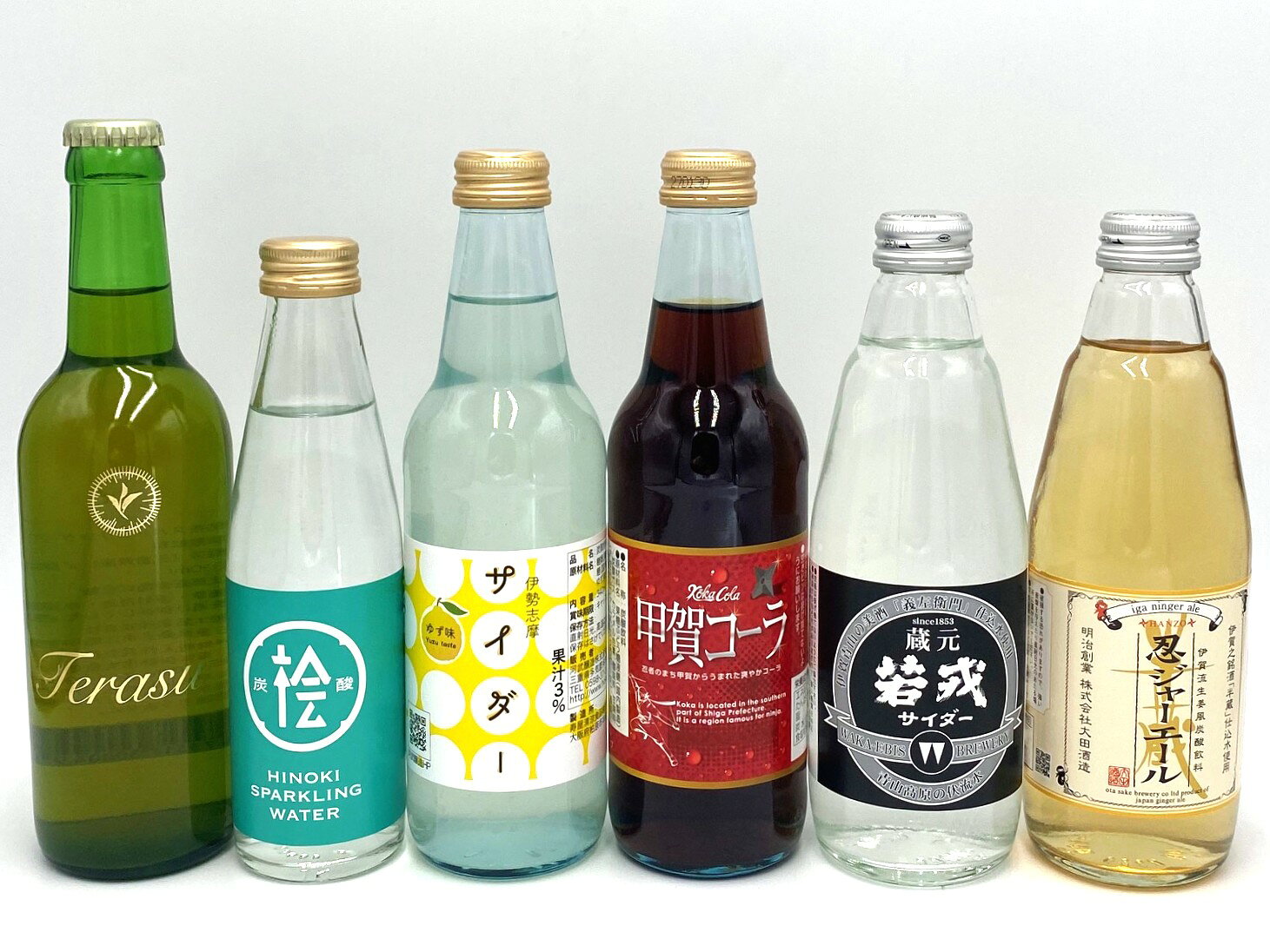 商品概要 三重・伊賀・甲賀のご当地ドリンクバラエティーセット。 商品詳細 大田酒造「忍ジャーエール」 名称 炭酸飲料 内容量 350mL 原材料 砂糖、果糖ぶどう糖液糖（国内製造）／炭酸、クエン酸、香料、クエン酸ナトリウム、着色料（カラメル色素） 保存方法 常温 販売者 株式会社大田酒造（三重県伊賀市上之庄1365ー1） 特徴 伊賀の銘酒「半蔵」の仕込み水使用の伊賀流生姜風炭酸飲料。 若戎酒造「若戎サイダー」 名称 炭酸飲料 内容量 350mL 原材料 グラニュー糖（国内製造）／炭酸、香料、クエン酸、リンゴ酸 保存方法 常温 販売者 若戎酒造株式会社（三重県伊賀市阿保1317） 特徴 伊賀青山の美酒「義左衛門」仕込み水使用 伊勢茶スパークリング Terasu 名称 炭酸飲料 内容量 330mL 原材料 緑茶（三重県産）／炭酸 保存方法 常温 販売者 伊勢商人株式会社（三重県伊勢市大倉町1553-123） 特徴 冷してお飲みいただくのがおすすめの、伊勢茶スパークリング - Terasu -。 初めはフルーティーで爽やかな口当たりが、常温になるにつれ、お茶本来の旨みが顔を出します。料理にあわせて、Terasuの味わいも変化していきます。 シャンパングラスでお飲みいただくことで、より香りが引き立ちます。 桧の炭酸水 名称 炭酸飲料 内容量 200mL 原材料 水／炭酸、香料（ヒノキ（三重県産）） 保存方法 常温 販売者 伊勢商人株式会社（三重県伊勢市大倉町1553-123） 特徴 三重県産のヒノキを100%使用した、ヒノキの香りが楽しめる炭酸水です。 伊勢志摩サイダーゆず味 名称 炭酸飲料 内容量 340mL 原材料 糖類（ぶどう糖果糖液糖（国内製造）、砂糖）、ゆず果汁／炭酸ガス 保存方法 常温 販売者 河武醸造株式会社（三重県多気郡多気町五桂234） 特徴 果汁3％。 甲賀コーラ 名称 炭酸飲料 内容量 340mL 原材料 果糖ぶどう糖液糖（国内製造）／炭酸ガス、カラメル色素、酸味料、甘味料（アセスルファムK、スクラロース）、香料、カフェイン（抽出物） 保存方法 常温 販売者 滋賀酒造株式会社（滋賀県甲賀市水口町三本柳39） 特徴 忍者のまち甲賀から生まれた爽やかコーラ 「のし」「ギフト包装」非対応です 当商品は「のし」「ギフト包装」を承ることができません。 注文画面にてご指定頂いても、対応いたしかねますのでご了承ください。
