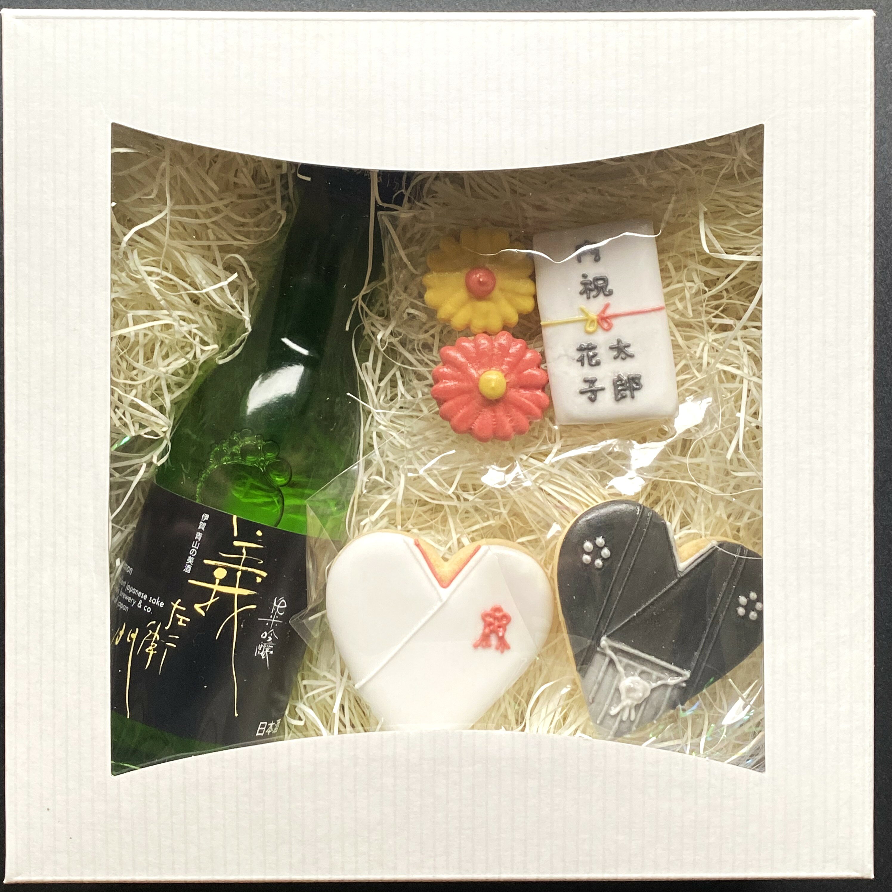 商品概要 お酒好きのカップルの「らしさ」満点！ 内祝いギフト ご結婚の内祝いに、お酒好きのカップルの「らしさ」満点のアイシングクッキーギフトはいかがですか？ お酒は伊賀酒180mlの小瓶3種から選べます。 こちらの和装ウェディングバージョンは、名入れができます。 商品詳細 アイシングクッキー 品名 焼菓子 内容量 5個 原材料 薄力粉、卵、無塩バター、粉糖、乾燥卵白、竹炭、レモン果汁／香料、着色料（赤色3号・40号、黄色4号・5号、青色1号・2号） 保存方法 常温 製造者 HONEY ～icing cookies～（伊賀市川西579-1） 特徴 袴／白無垢／のし＜名入れ＞／花×2 「のし」ご希望の場合 当商品は「のし」対応商品です。 注文画面にて備考欄にご入力ください。 「ギフト包装」ご希望の場合 当商品はギフトラッピング対応商品です。 注文画面にて備考欄にご入力ください。