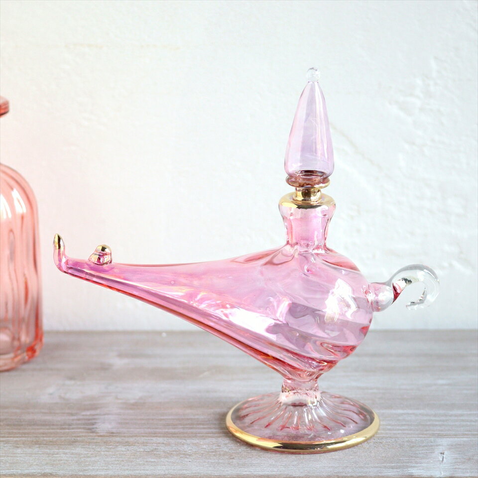 エジプトガラス香水瓶　アラジンランプ　Egyptian Perfume Bottle Aladdin Lamp　ピンク オプティックサイズ高さ13.5cmx14cm材　質ガラス制　作エジプトアラジンランプの形が、アラビアンな雰囲気たっぷりの香水瓶。エジプトのカイロにて、職人さんが一つ一つ手作りしたものです。つややかなガラスの輝きと、きらりと光るゴールドがエキゾチックなゴージャスさを醸し出しています。色違いやサイズ違いを並べて、お部屋にアラビアンなテイストをプラスできます。実際に香水瓶として使うこともできますが、やや密閉性が低いので、置物・飾り・などとしてお楽しみください。※高さが13.5cm、持ち手から注ぎ口の先までの長さが14cmです。※箱はついていません。エアキャップで包んでお届けします。※手作り品のため、個体差がありますので、若干サイズの誤差がございます。ガラス香水瓶・エジプト香水瓶・エジプトガラス・エジプト・お土産・カイロ・ガラス工芸・アラジンランプ・インテリアオブジェ・アロマテラピー・エジプト・ハンドメイド・パルファム・エジプトお土産・カイロ・アレキサンドリア・地中海・香油