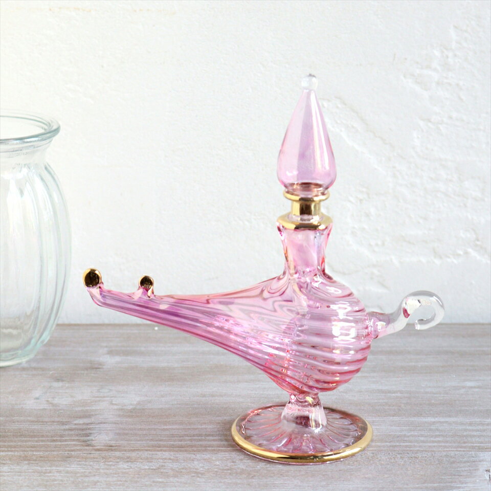 エジプトガラス香水瓶　アラジンランプ　Egyptian Perfume Bottle Aladdin Lamp　ピンク オプティックサイズ高さ12cmx12cm材　質ガラス制　作エジプトアラジンランプの形が、アラビアンな雰囲気たっぷりの香水瓶。エジプトのカイロにて、職人さんが一つ一つ手作りしたものです。つややかなガラスの輝きと、きらりと光るゴールドがエキゾチックなゴージャスさを醸し出しています。色違いやサイズ違いを並べて、お部屋にアラビアンなテイストをプラスできます。実際に香水瓶として使うこともできますが、やや密閉性が低いので、置物・飾り・などとしてお楽しみください。※高さが12cm、持ち手から注ぎ口の先までの長さが12cmです。※箱はついていません。エアキャップで包んでお届けします。※手作り品のため、個体差がありますので、若干サイズの誤差がございます。ガラス香水瓶・エジプト香水瓶・エジプトガラス・エジプト・お土産・カイロ・ガラス工芸・アラジンランプ・インテリアオブジェ・アロマテラピー・エジプト・ハンドメイド・パルファム・エジプトお土産・カイロ・アレキサンドリア・地中海・香油