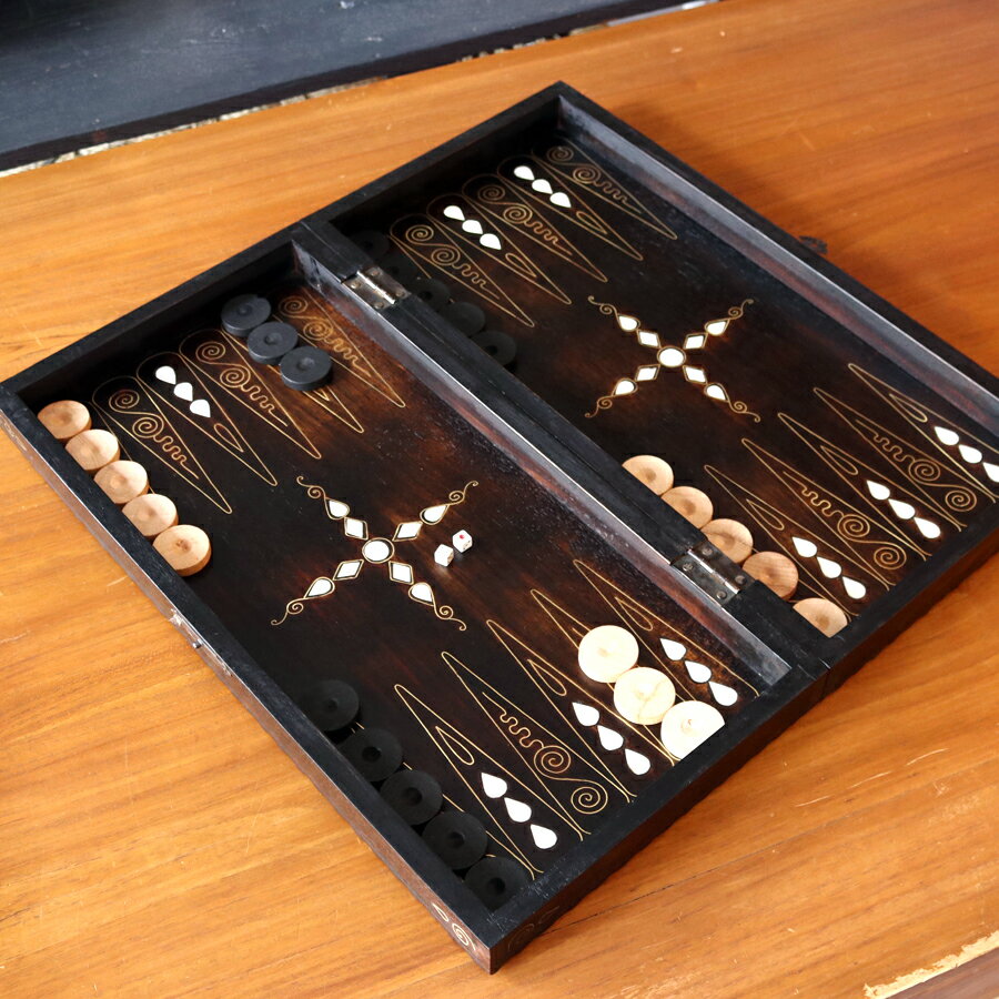 ゲームボードゲーム盤・2色駒とサイコロ付">バックギャモン Backgammon 折り畳み式 螺鈿模様 ゲームボードゲーム盤・2色駒とサイコロ付サイズ（盤面を開いた時）：50.5×50.5×4cmサイズ（折りたたみ時）：50.5×25.5×8.5cm材　質：木製産　地：トルコトルコ＆アラブを中心とした中東圏では一般的に知られる、歴史あるボードゲーム「バックギャモン」。世界4大ゲームのひとつとされ、現在でも世界大会が行われるほどの人気のゲームです。二つ折りになっている内側が、バックギャモン用の盤面、裏を返すと螺鈿細工が施されています。バックギャモン用の2色の木製の駒15個ずつとサイコロ2個が付属します。トルコの家庭で親しまれているゲーム用の商品で、競技用ではありません。【螺鈿細工】オスマン帝国時代に、トルコ南部やシリアから伝えられた伝統工芸品で、真珠母貝（主にアコヤガイ）の貝殻の内側の真珠質をはめ込んだ螺鈿細工。表と裏に豪華に装飾されています。インテリアとしても存在感のあるアイテムです。ゲームボードゲーム盤・2色駒とサイコロ付">ゲームボードゲーム盤・2色駒とサイコロ付">ゲームボードゲーム盤・2色駒とサイコロ付">ゲームボードゲーム盤・2色駒とサイコロ付">ゲームボードゲーム盤・2色駒とサイコロ付">ゲームボードゲーム盤・2色駒とサイコロ付">ゲームボードゲーム盤・2色駒とサイコロ付">KEY:ゲーム盤、すごろく、バックギャモン,　Backgammon, tavla, オセロ、チェス、輸入ゲーム,トルコ雑貨,エジプト雑貨