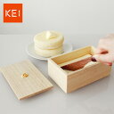 KEI ケイ 京指物 バターケースの解説上質な桐の木のキッチン用品、バターナイフ付きのバターケースです。 調湿性、防虫性に優れた木製なので冷蔵庫に入れてもケースが冷たくなりません。 「KEI」は京都の伝統工芸「京指物」を現代の生活文化に合わせて進化させたブランド。全て職人による手作業で丁寧に仕上げられた、桐のキッチン用品です。 桐は古来から収納家具の材料に重宝され、「軽い」木材としても有名です。 KEIの桐材は、AAA（トリプルA）を獲得した上質な材料を贅沢に使用しております。 専用のギフトボックス入りですので、贈り物に最適です。 KEI ケイ 京指物 バターケースの詳細 商品名： KEI ケイ 京指物 バターケース 説明： バターを入れる桐箱のケース(容器) 木製のカッター付きバターケース 木のバターナイフ ふた付きの木箱 バター入れ カテゴリー： キッチン雑貨/キッチン用品/保存容器 用途： バターの保存 ギフト用途： 結婚祝い/母の日/新築祝い/引っ越し祝い/引き出物 別表記： 桐の箱/バター入れ物商品名 KEI ケイ 京指物 バターケース サイズ（約） W150 D90 H60（内寸 W140 D80 H50） 重量（約） 110g 材質 桐、ウォールナット（ウレタン塗装）、真鍮（金メッキ） 生産国 日本 注意 ※手作りのため、寸法につきまして多少の違いはご了承下さい。 ※天然木を使用しているため、木目や色見はそれぞれ異なります。 デザイナー・ディレクター　：　梅野 聡(UMENODESIGN) 建築を学び都市開発事業に従事後、家具メーカー勤務。その後2003年にUMENODESIGN設立。プロダクトデザインを中心に様々な企業や伝統工芸品などのプロデュース、ブランディングを手がけながらインテリア、ファッション、ウェブ、グラフィック、パッケージなど多岐に渡る分野で活動。 日本を代表する若手デザイナー7名に選出「経済産業省 JAPAN DESIGN+」。 その後、世界のデザイナー10名にアジアで唯一選ばれイタリアLEUCOS社の「 LIGHT YOUR HERT」に参加するなどUMENODESIGNの作品は国内はもちろん欧米を中心に海外の展示会でも数多く出品され世界で販売されている。 KEI京都の伝統工芸「京指物」を現代の生活文化に合わせて進化させたブランド「KEI」。 娘が誕生すると桐を庭に植え、嫁ぐ際に桐箪笥にして嫁入り道具とする習慣がありました。箪笥の習慣がなくなりつつある現代において新しい嫁入道具をテーマにプロジェクトは始まりました。 UMENODESIGNがディレクションを手がけ京指物にこだわりを詰め込んだ物作りへと発展させ、全て職人による手作業で丁寧に仕上げています。 「KEI」では長く親しまれる京指物の可能性をこれからも発信いたします。 KEI 商品一覧はこちらから 塩胡椒ケース スパイスラック パスタケース ブレッドケース