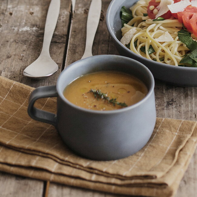 1972年に滋賀県で創業し、洗練されたデザインが人気のキッチン・インテリア雑貨ブランド「KINTO」。磁器製スープカップは、ニュアンスのあるフォルムで手になじみやすい一品です。カラーはアッシュホワイトとダークグレーの2色。２個セットなので同色で頼むもよし、組み合わせてもよしです。