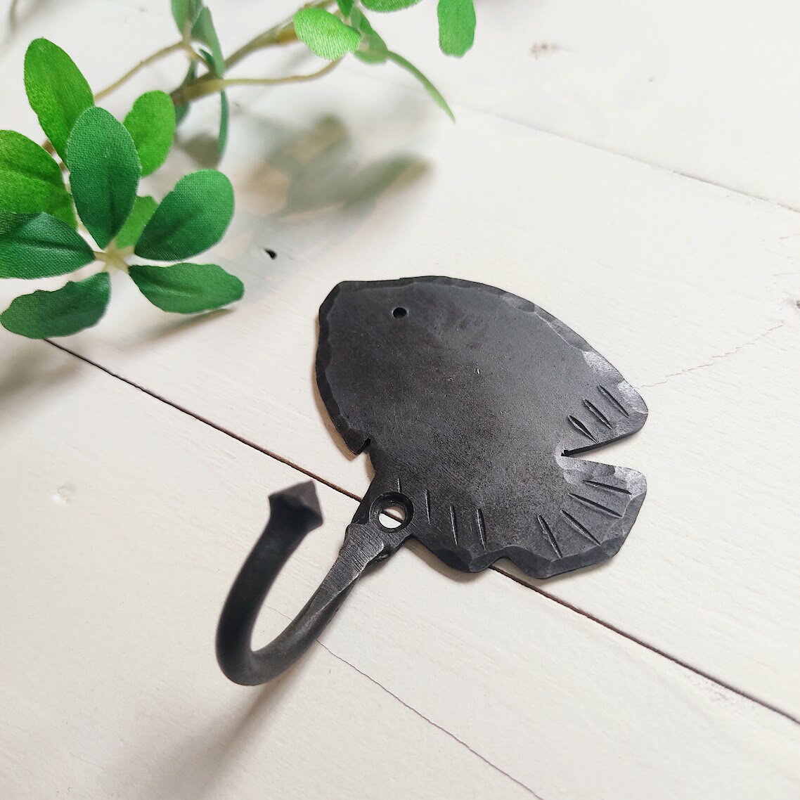 商品情報商品名【商品名】サカナフックサカナモチーフが可愛らしいアイアンフックです。ドアや壁に可愛いワンポイントを♪ 商品詳細【サイズ】約 縦7.5cm×横6.5cm×奥行3cm【材　質】：アイアン※ネジは付属しておりません。 その他※在庫数の更新は随時行っておりますが、お買い上げ頂いた商品が品切れになってしまう事もございます。その場合、お客様にご連絡を致しますが、メーカー廃盤などにより入荷予定がない場合はキャンセルとさせて頂く場合もございますことをあらかじめご了承下さい。※当該商品以外の写真に写っている商品は付属致しません。サカナフック アイアンフック さかなモチーフ 動物モチーフ ウォールフック 収納 見せる収納 ディスプレイ キノコモチーフ 壁掛け 黒 ブラック アンティーク調 ナチュラル雑貨 カントリー雑貨 ガーデン雑貨 カフェ風 PRAH-945 ユニークな魚のシルエットが可愛らしい、アンティーク調のアイアンフック シンプルながら存在感のあるデザインで壁面を楽しく彩りますハンドメイドならではの素朴な風合いと、無骨なアイアンの質感がナチュラルな空間によく馴染みますキッチンではミトンやクロス掛けに、玄関では鍵や小物の収納に、ガーデンではツールやオーナメントのディスプレイにも活躍アイアン特有の重厚感もありながら可愛いデザイン実用性とインテリア性を兼ね備えたフックですビス止めするだけ！簡単取付！★こちらの商品もぜひ♪きのこフック 2
