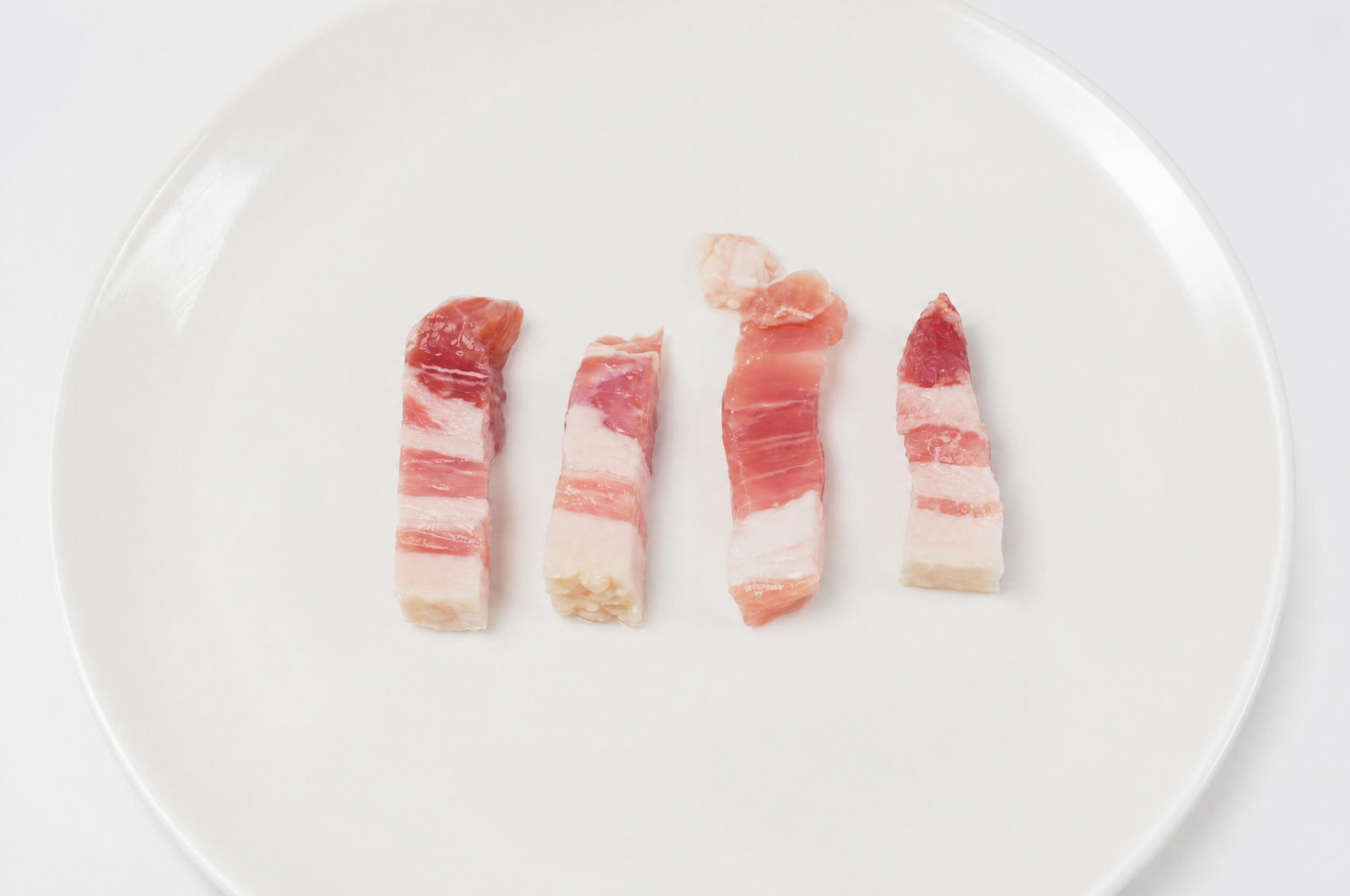 豚肉の旨みとコクのある脂を楽しめる、パンチェッタを使いやすい12mm幅の短冊状にカットしました。 程よい塩味と豚肉の豊かな風味が特徴で、加熱することで脂がじゅわっと溶け出し、料理に深い旨みを加えてくれます。 パスタやカルボナーラはもちろん、ピザ、スープ、炒め物、サラダなど、さまざまな料理にお使いいただけます。 カットする手間がなく、そのままフライパンに入れて調理できるので、普段の料理にも便利な一品です。 パスタやピザなどのイタリア料理に、パンチェッタの濃厚な旨みをプラスしてお楽しみください。 原材料：豚バラ肉（デンマーク）、食塩、ブドウ糖、砂糖、水あめ／リン酸塩（Na）、調味料（アミノ酸）、酸化防止剤（V.C）、発色剤（亜硝酸Na）、香辛料抽出物 栄養成分：エネルギー：321kcal　/たんぱく質：12.5g　/脂質：30.7g　 /炭水化物：1.1g　/食塩相当量：2.0g アレルギー原材料：豚肉豚肉の旨みとコクのある脂を楽しめる、パンチェッタを使いやすい12mm幅の短冊状にカットしました。 程よい塩味と豚肉の豊かな風味が特徴で、加熱することで脂がじゅわっと溶け出し、料理に深い旨みを加えてくれます。 パスタやカルボナーラはもちろん、ピザ、スープ、炒め物、サラダなど、さまざまな料理にお使いいただけます。 カットする手間がなく、そのままフライパンに入れて調理できるので、普段の料理にも便利な一品です。 パスタやピザなどのイタリア料理に、パンチェッタの濃厚な旨みをプラスしてお楽しみください。 原材料：豚バラ肉（デンマーク）、食塩、ブドウ糖、砂糖、水あめ／リン酸塩（Na）、調味料（アミノ酸）、酸化防止剤（V.C）、発色剤（亜硝酸Na）、香辛料抽出物 栄養成分：エネルギー：321kcal　/たんぱく質：12.5g　/脂質：30.7g　 /炭水化物：1.1g　/食塩相当量：2.0g アレルギー原材料：豚肉