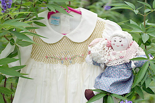 *********************************************{ &#127800;"小さな才能に花が咲く!!"&#127800; ☆"プレシャスギフトfor Your Baby!!"☆ ********************************************* &#10047;胸元のゴージャスなハンドメイドの&#10047;スモッキングに花柄の刺繍!! &#10047;品格ある清楚なお嬢様ドレスです。 &#10047;およばれの時にも普段着としても&#10047;かわいらしさ抜群!! ◎色:オフホワイト ◎サイズ：90CM(24M・着丈43CM) &#10047;背中ボタン留め &#10047;ブルマ付きです。 ○画像と多少色具合が異なる場合もございます。○ご承知下さい。 ♪ギフトラッピングは、無料サービスです。*********************************************{ &#127800;"小さな才能に花が咲く!!"&#127800; ☆"プレシャスギフトfor Your Baby!!"☆ ********************************************* &#10047;&#10047;永遠の定番!!"Sweet Angela" &#10047;&#10047;スモッキングドレスでリトルプリンセス!! &#10047;&#10047;胸元はゴージャスなスモッキング刺しゅうでドレッシー!! &#10047;&#10047;およばれにも普段着としても!! ♪♪おまけはカントリードール"コード—ヘアの女の 子!! &#10047;ようこそ!!"小さな才能に花が咲く!!"ローズガーデンへ!!