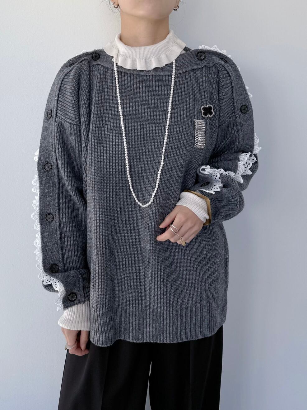 釦の開閉で色々な着方ができるニット