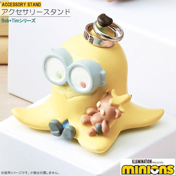 ILLUMINATION PRESENTS minions ミニオンズ お家でボブ＆ティムとほっこりシリーズ ●手のひらサイズの可愛いアクセサリースタンド。かわいく指輪を置いておけます。 ●指輪は頭部に掛けられます。リングを約2個掛けれます。 ●置いておくだけでも机の上のかわいいワンポイント！ ●贈り物ギフトにも おすすめです。 [商品仕様] ●商品サイズ（約）/横幅79×奥行67×高さ70mm ●主材質：ポリレジン（ラッカー塗装） ●生産国/中国 ●その他/箱入り ※実際の商品と掲載画像でお使いのモニター等の違いにより色合いが、多少違う場合がございます。 ※手作りの為、個体によってばらつきがありますのでご了承ください。 ※こちらの商品の在庫は少なめに設定されておりますので、ギフト等でまとまった数量をご希望のお客様はお問合わせください。 ※こちらの商品はのし巻きは対応しておりません。